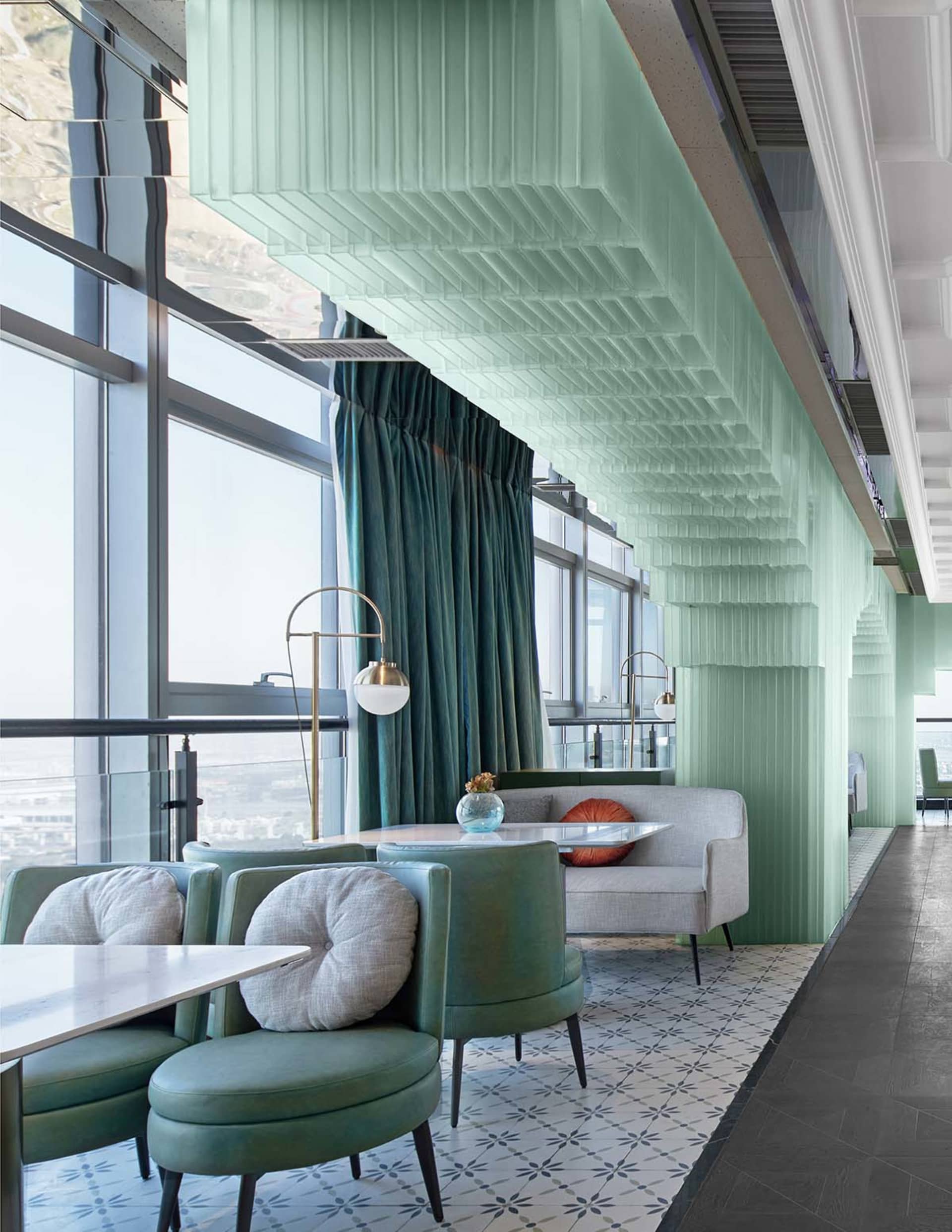 Modern restaurant interior with glass walls, concrete flooring, and tiled accents