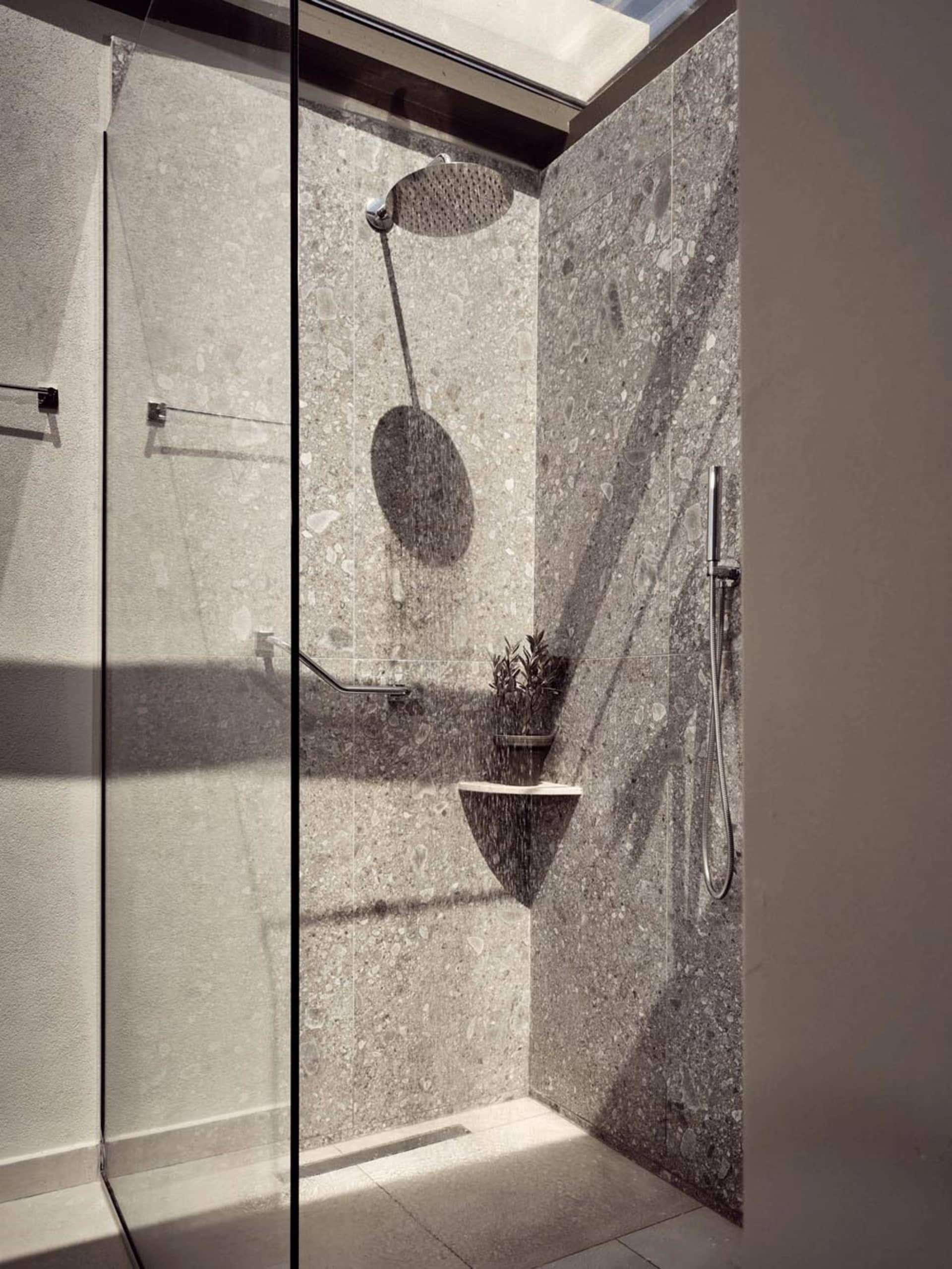 Industrial-style bathroom featuring a terrazzo shower stall with a glass enclosure, providing a modern and rustic ambiance.