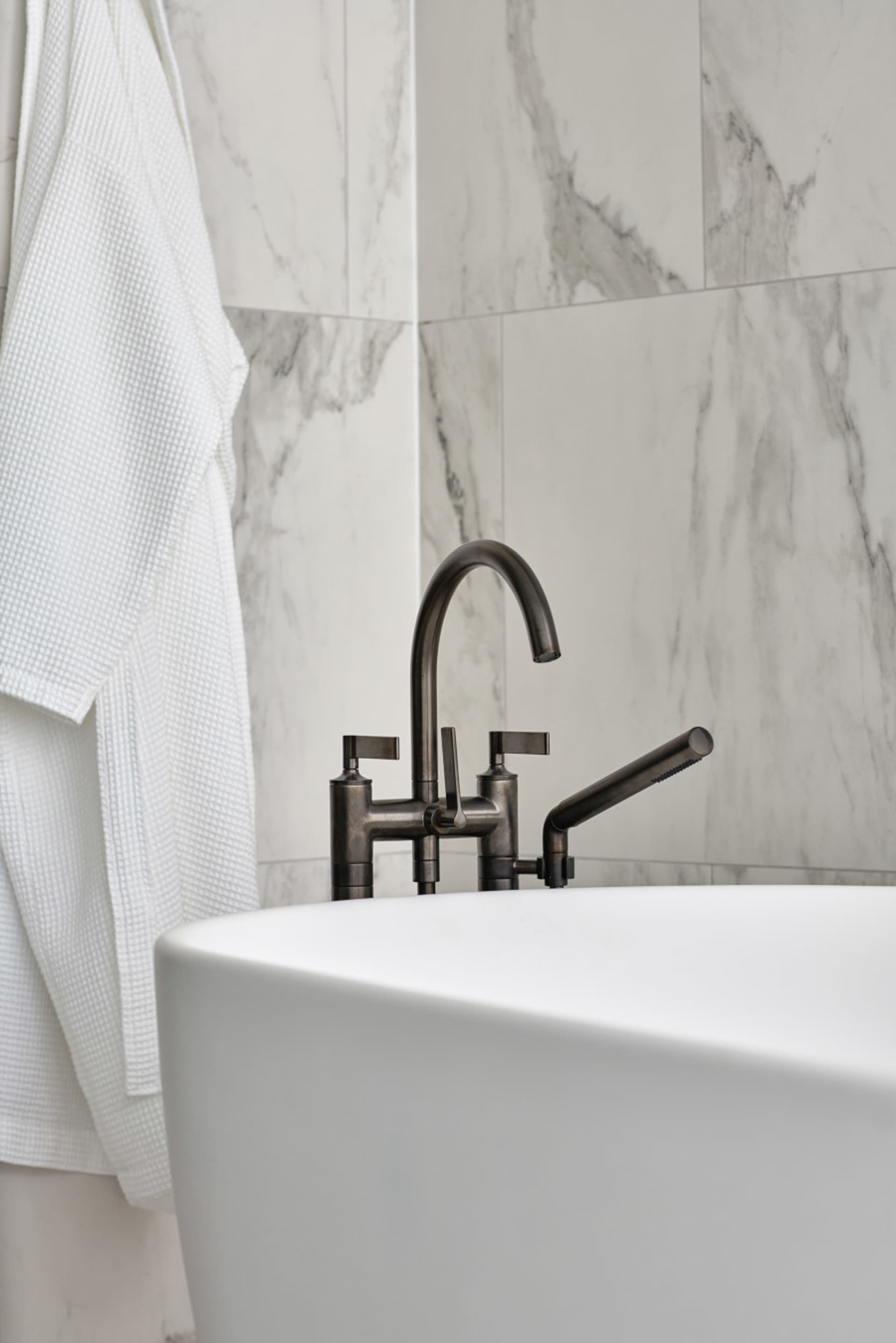 White marble bathroom with industrial faucet, minimalistic design.