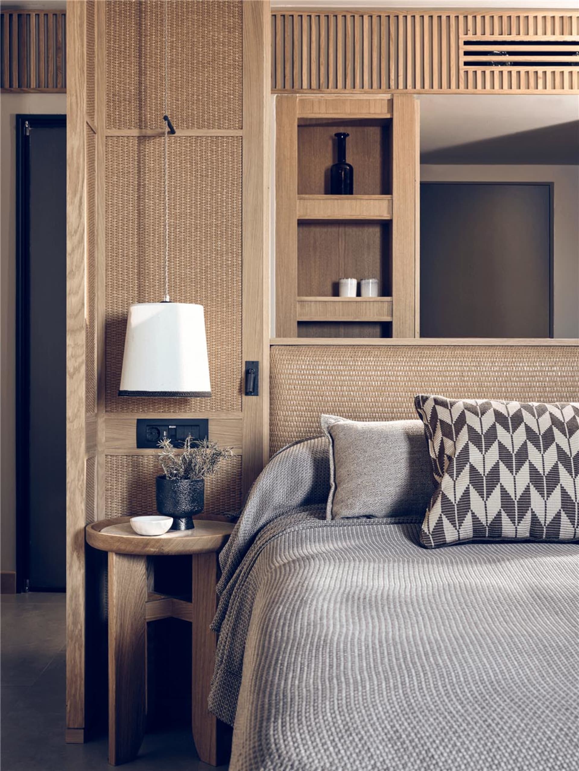 A minimalist bedroom with renewable materials and a light-colored wood bed frame and nightstand.