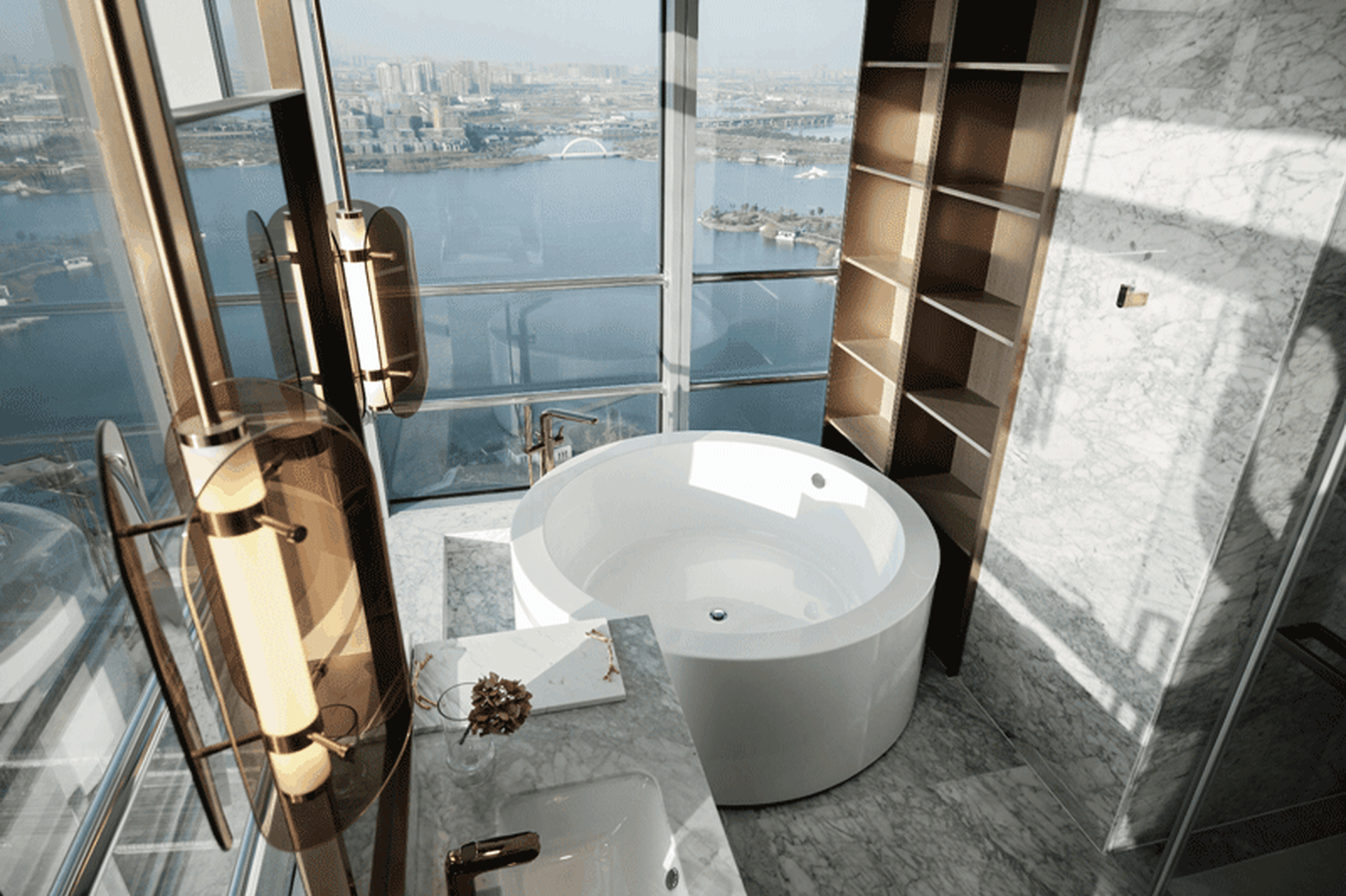 Modern bathroom with marble floor, bathtub, and floor-to-ceiling windows overlooking cityscape.
