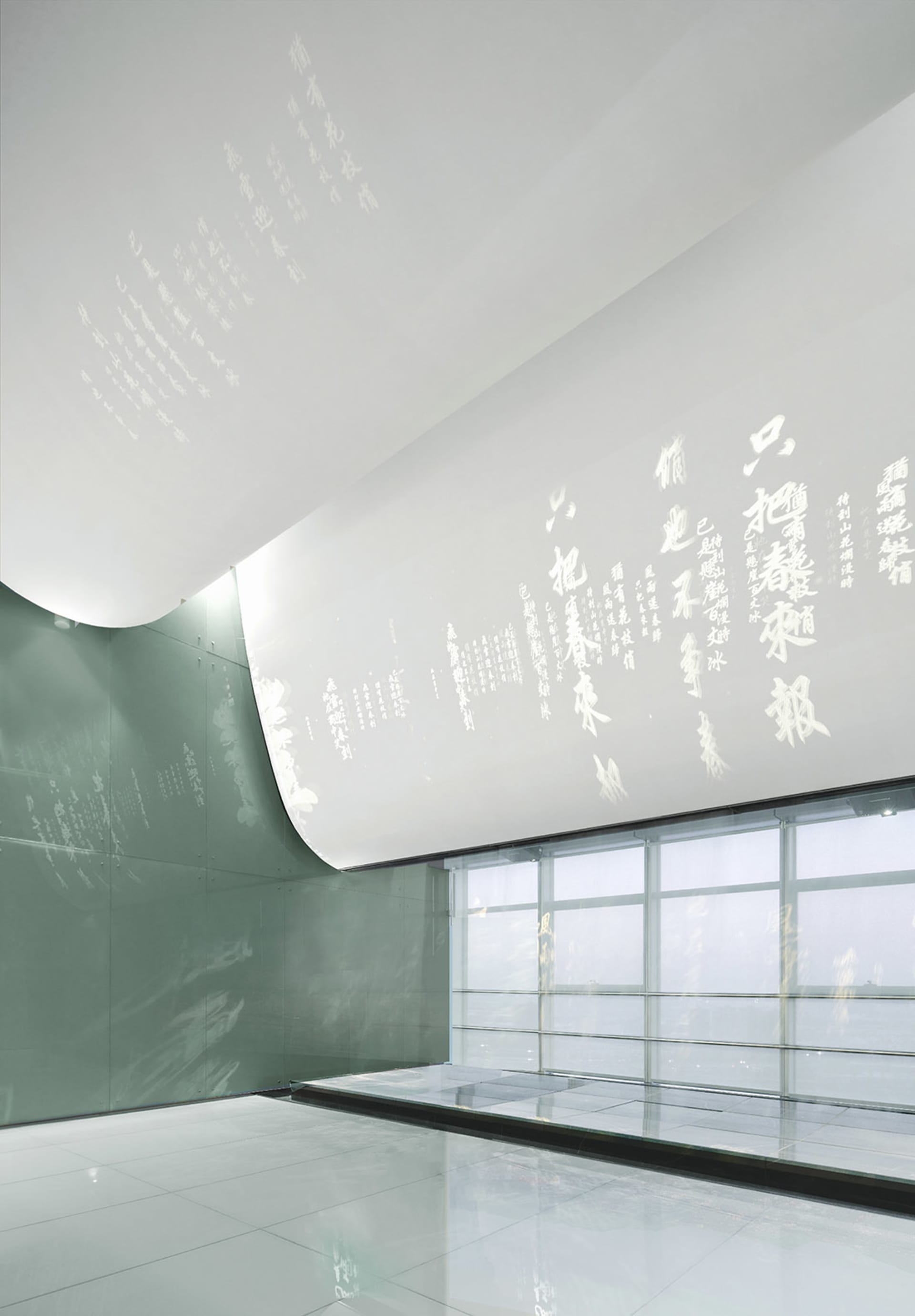 Modern installation art featuring textured paper on a curved wall and white room with glass partition.