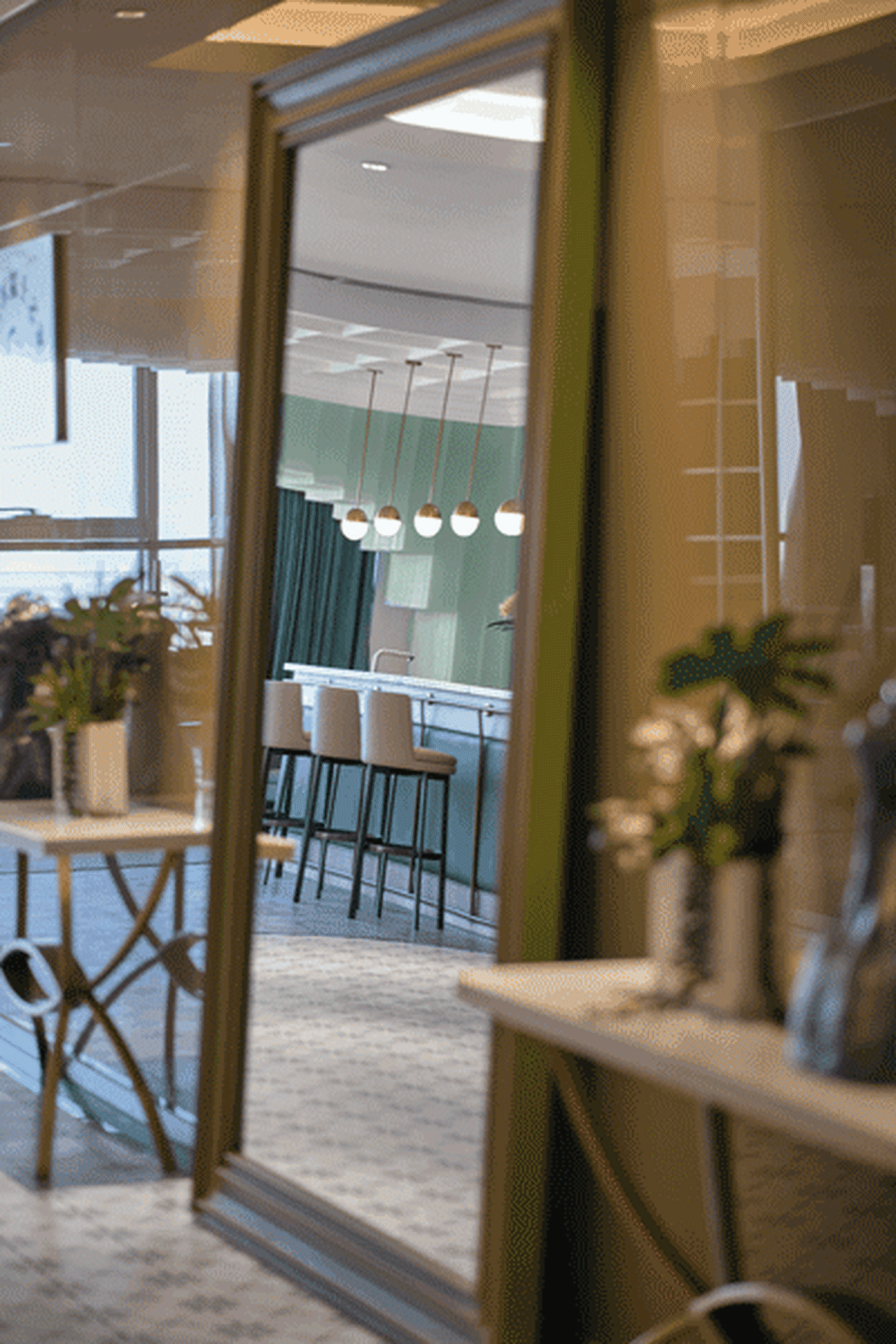 A modern open-plan office space with glass panels for walls and a bright, airy atmosphere.