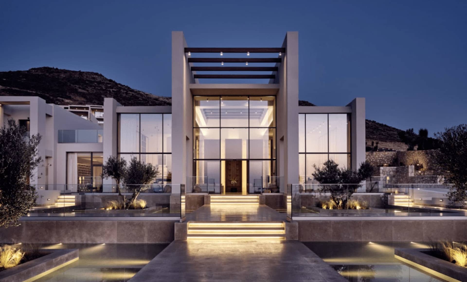 A modern residential exterior featuring large glass windows and doors.