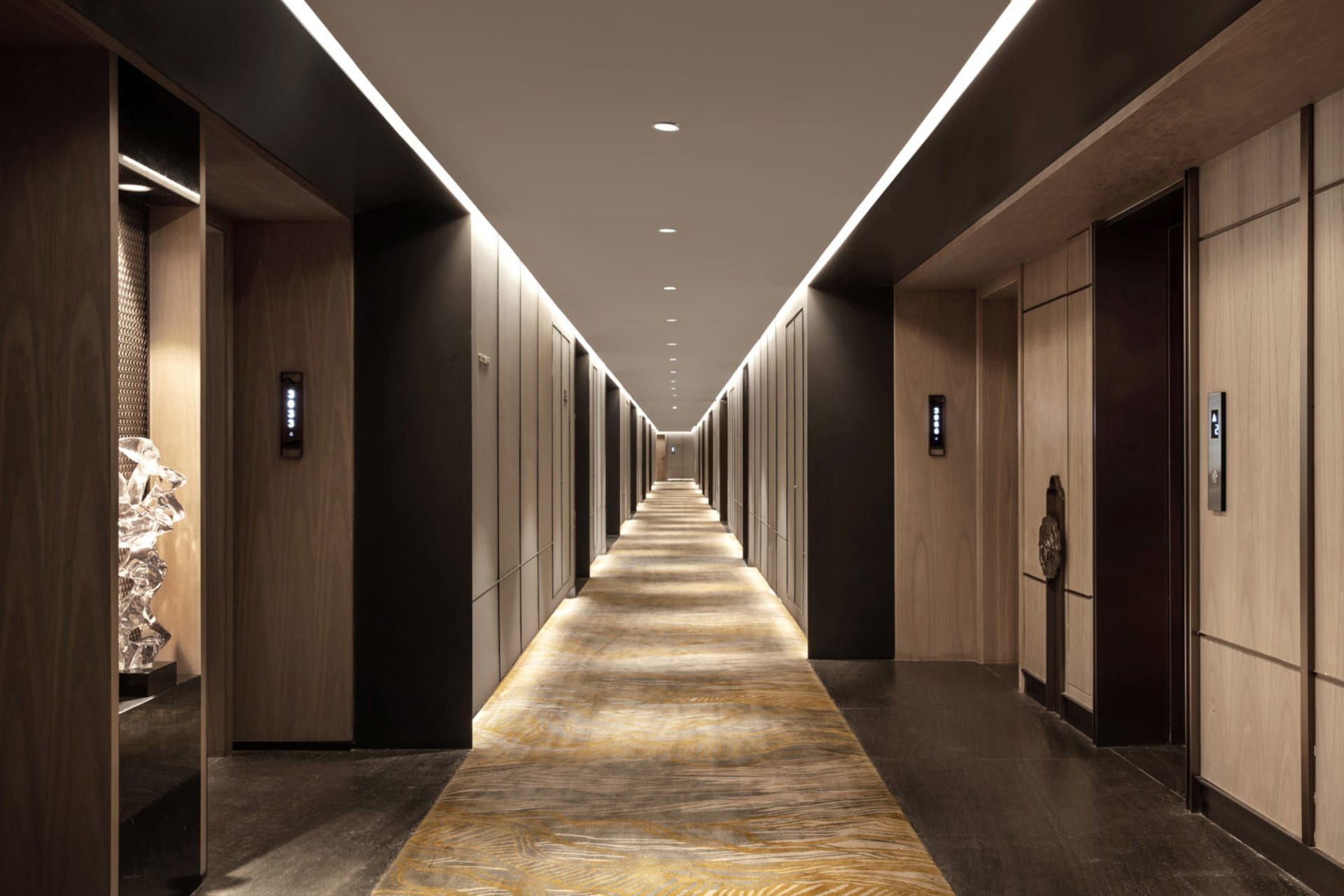 Modern, elegant hotel corridor lined with wooden tiles and featuring a long, empty hallway.