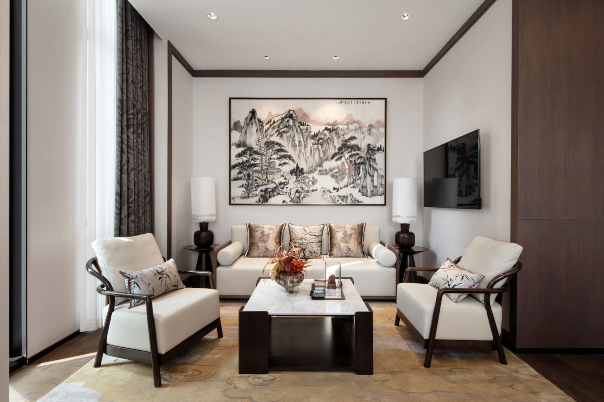 Living room with neutral-toned leather sofas, wooden coffee table, and abstract art on the wall