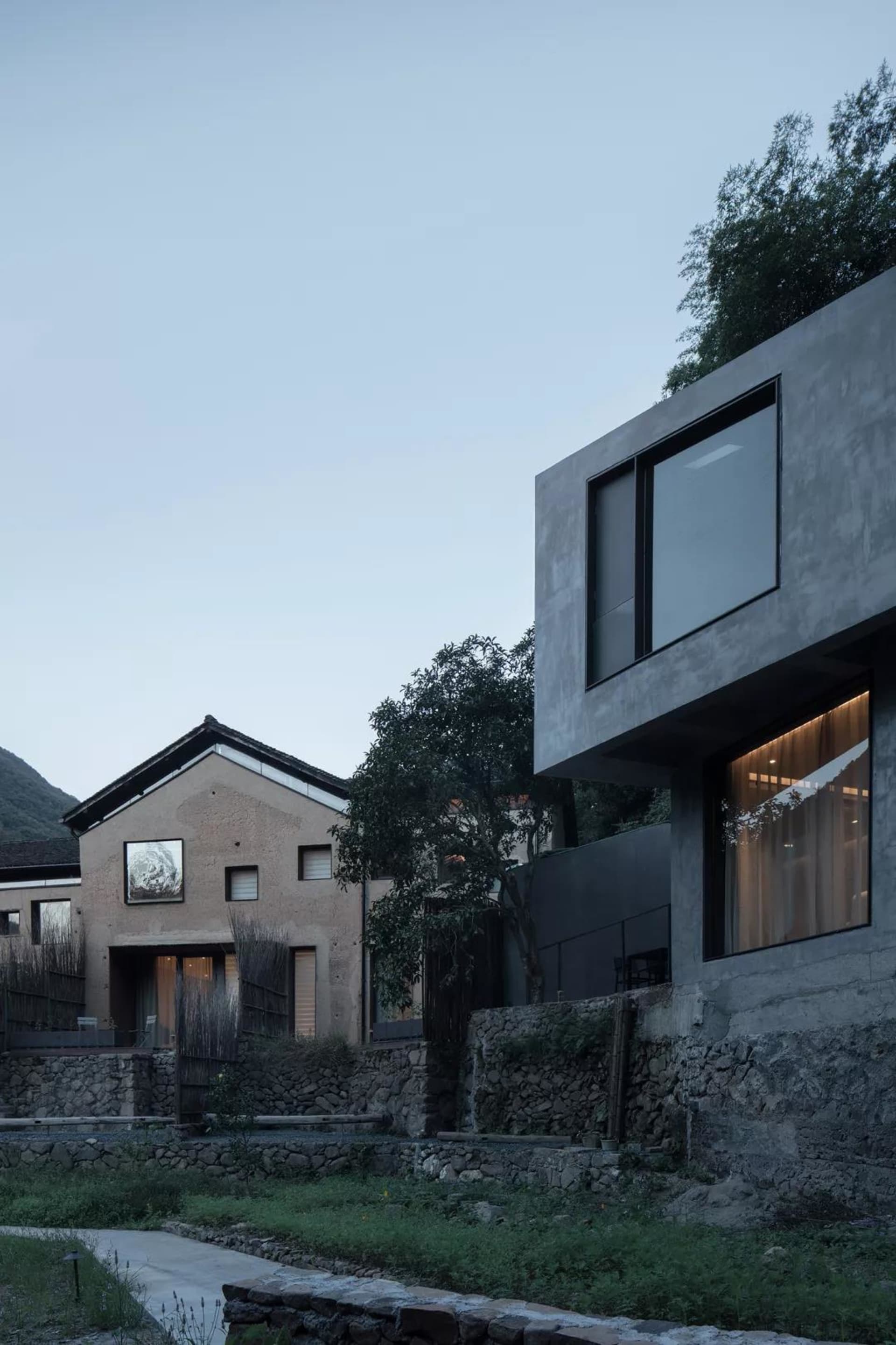 一座極簡住宅，擁有現代混凝土框架與俐落窗戶。
