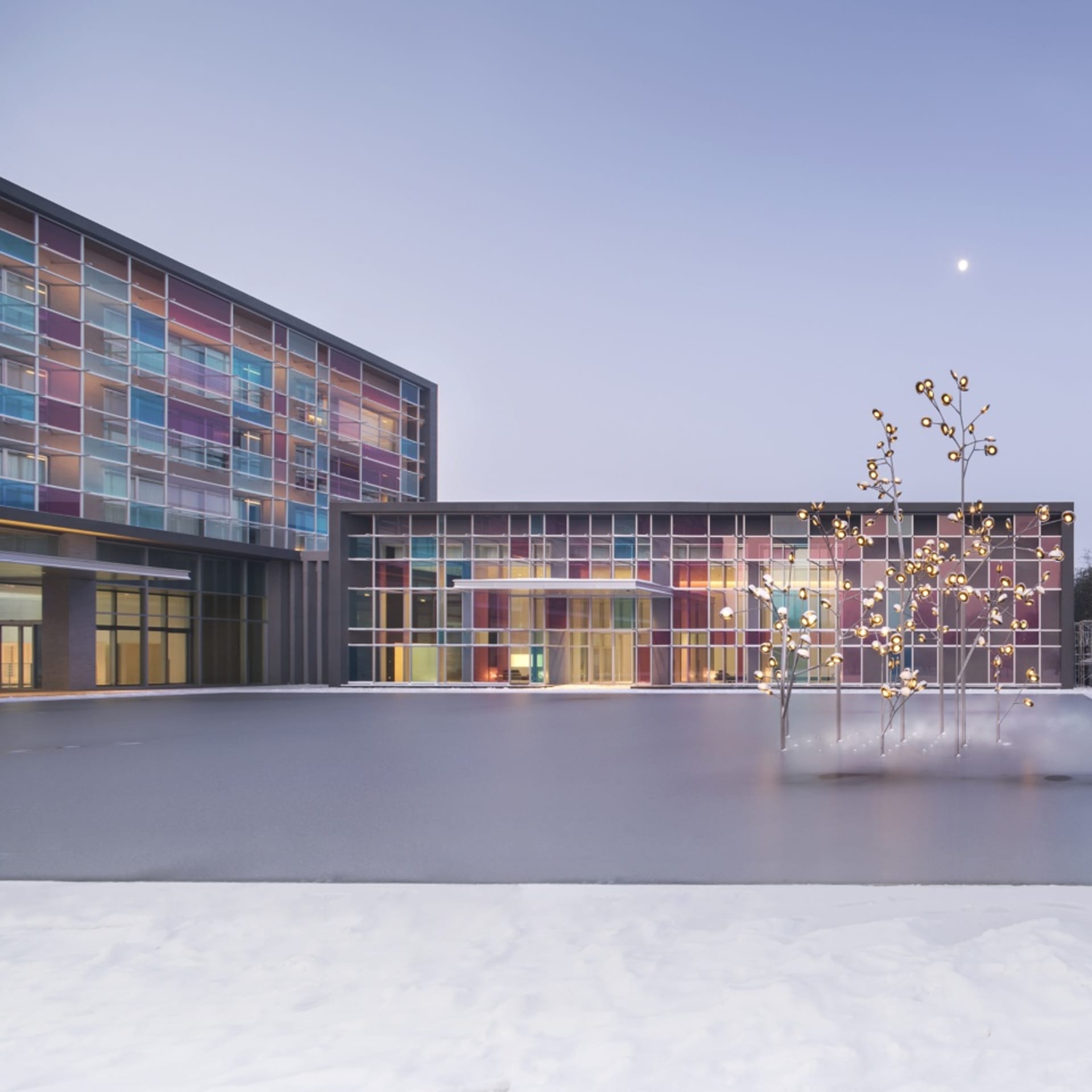 Modern office building with glass exterior and metal accents in snowy landscape