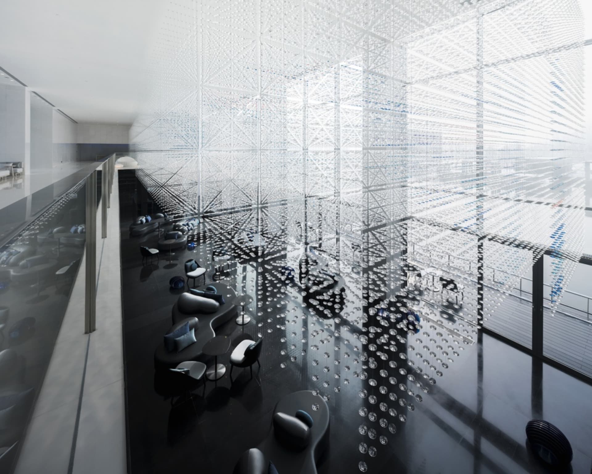 A modern hotel lobby featuring glass and concrete materials.