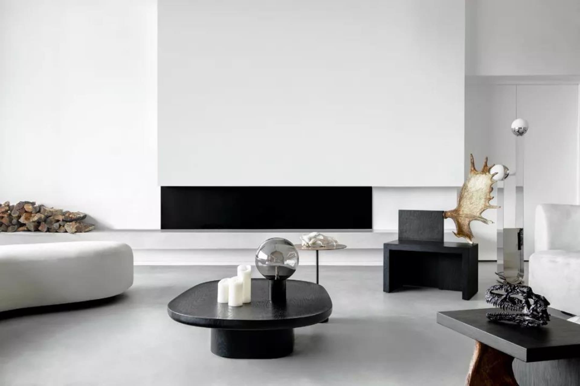 Modern minimalist living room with concrete floor, metal and wood furniture, and sleek black accents.