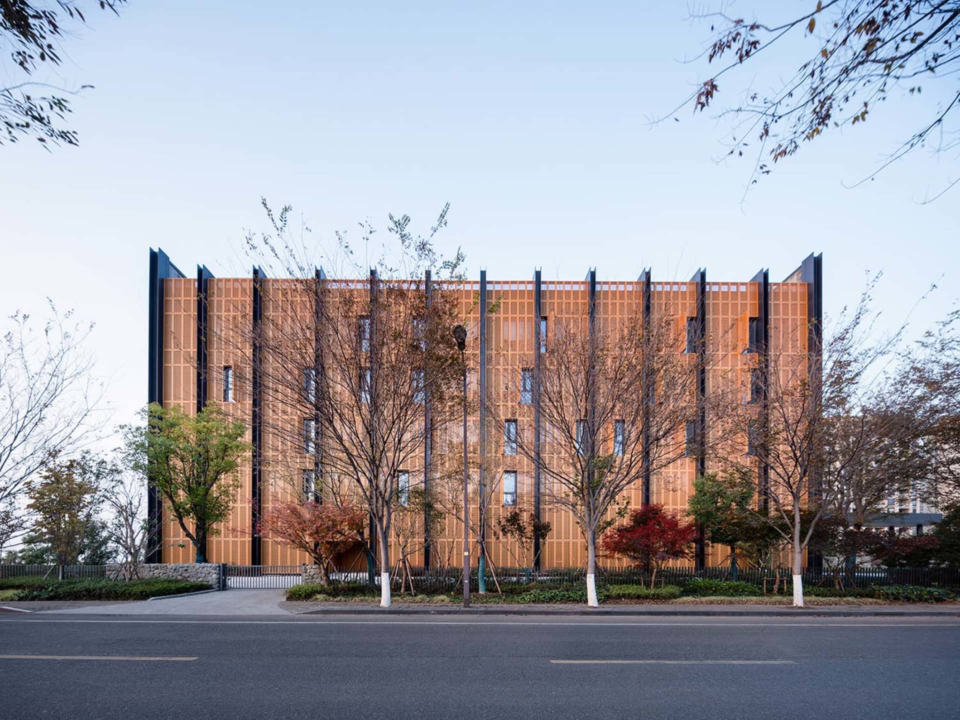 A modern architectural facade featuring a wooden exterior with large windows and vertical metal accents.