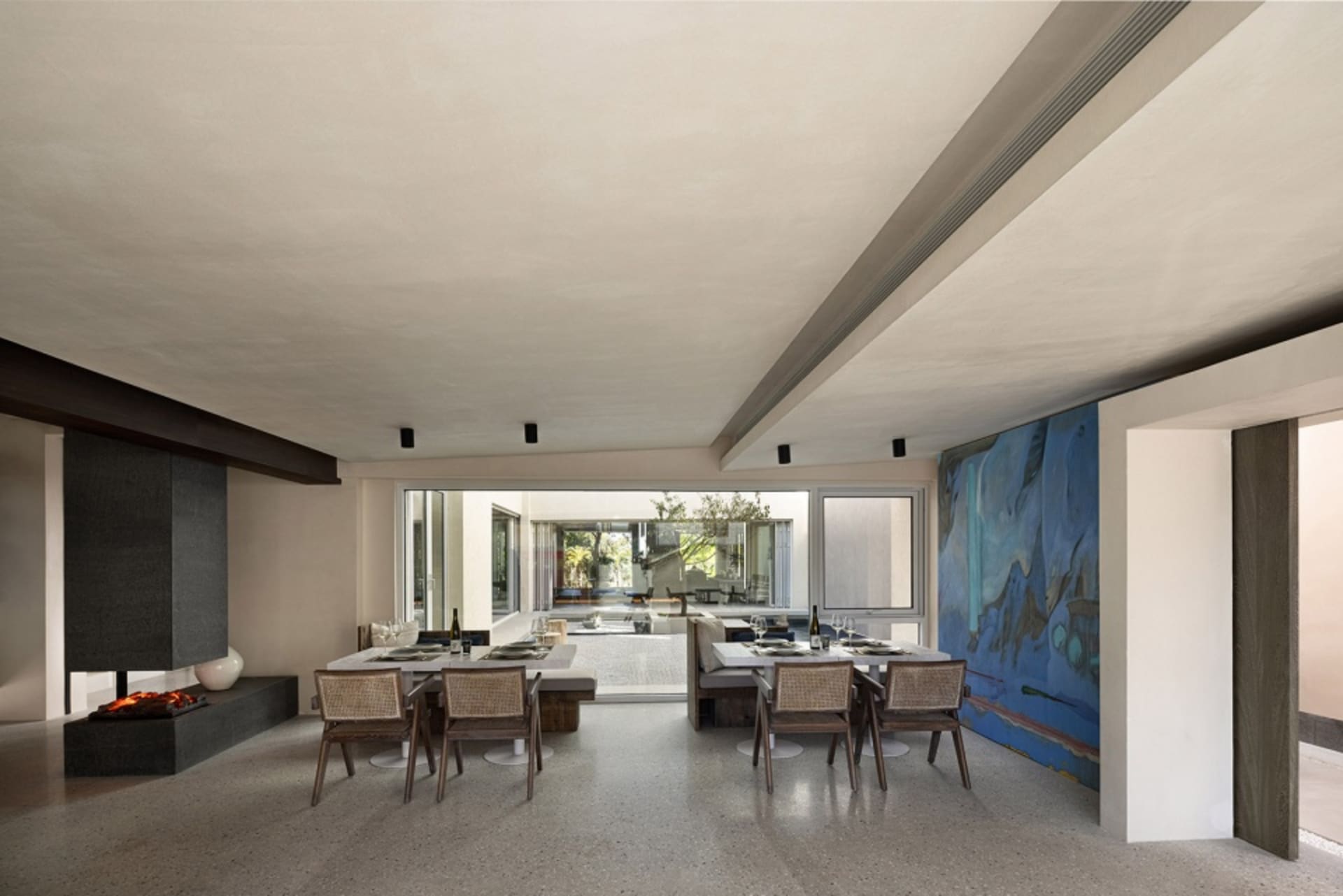 Modern dining room featuring a concrete floor, contemporary furniture, and large windows.
