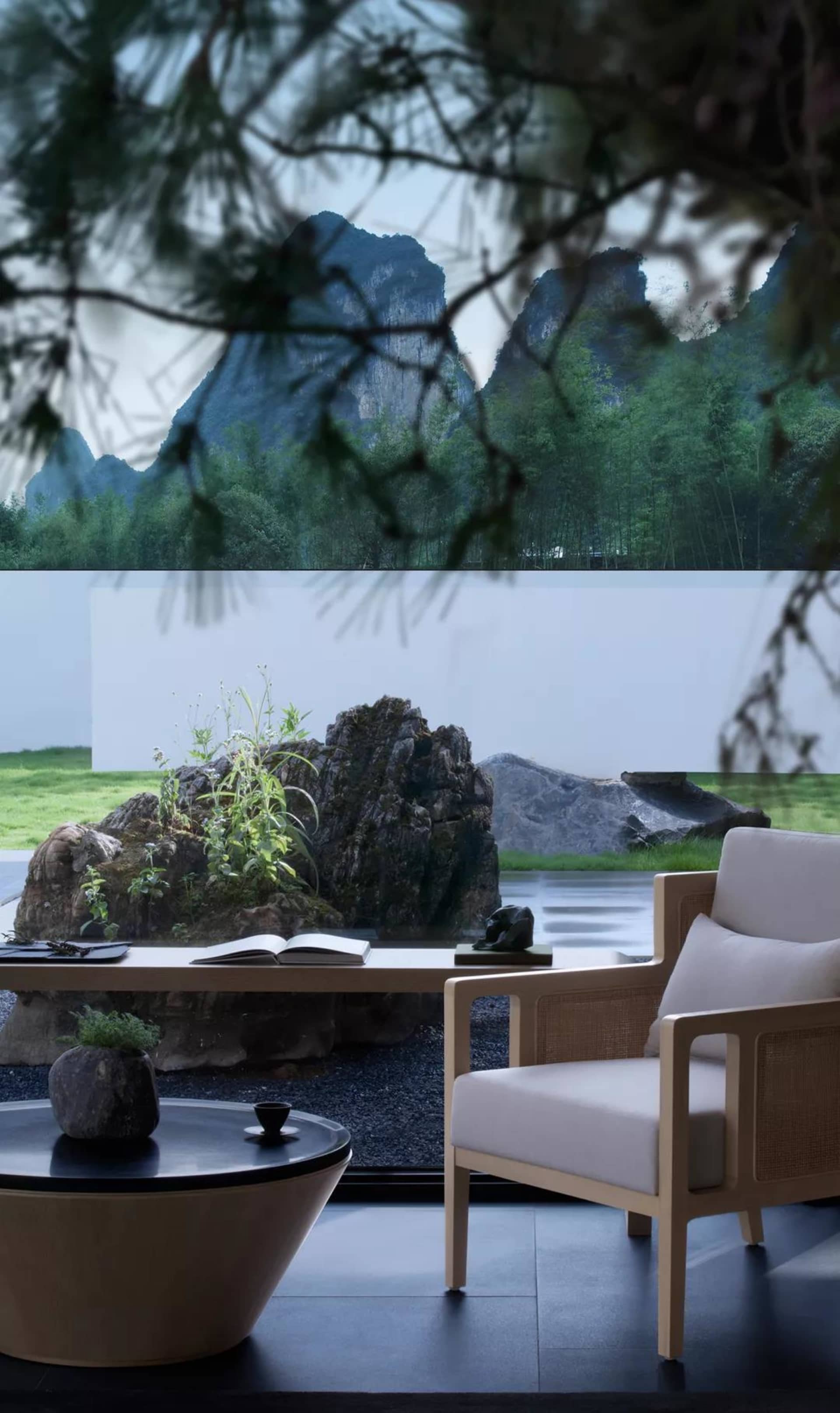 A minimalist white living room featuring a large window with a view of the natural landscape.