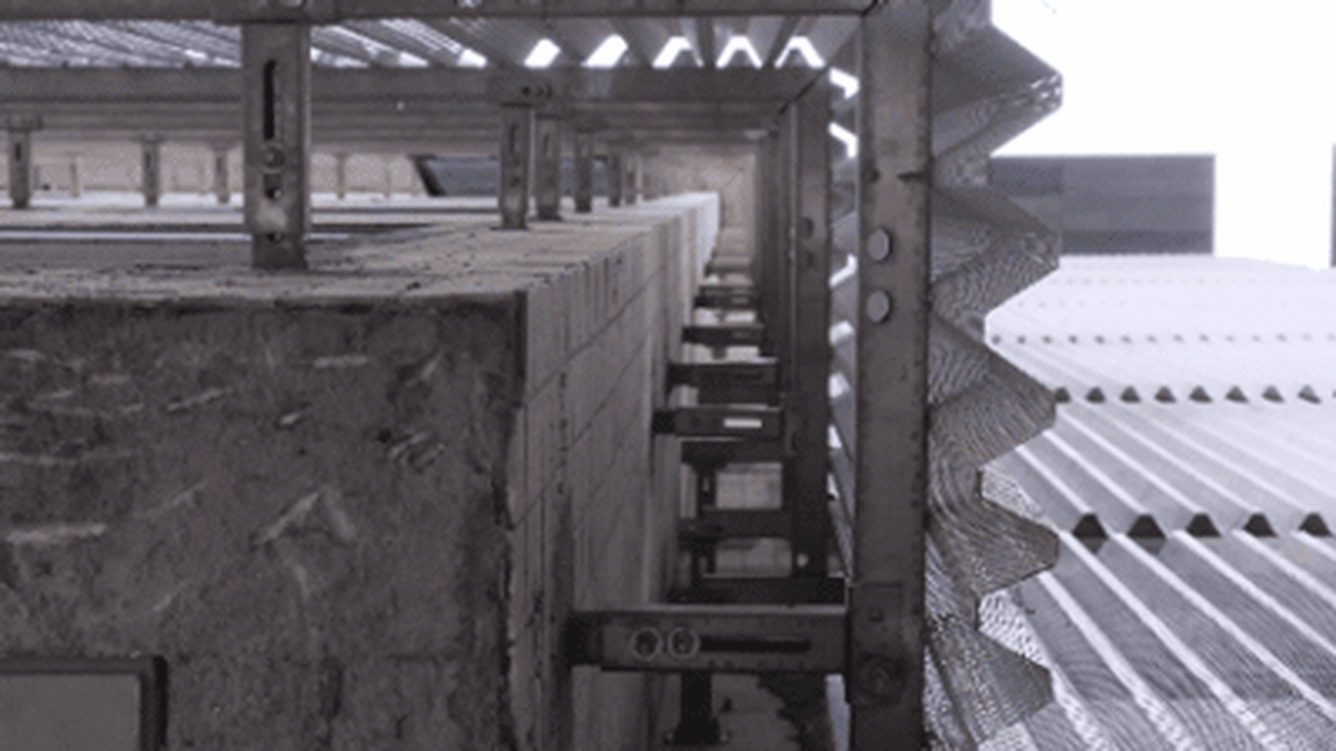 Industrial conveyor system with concrete embankments and metal guardrails