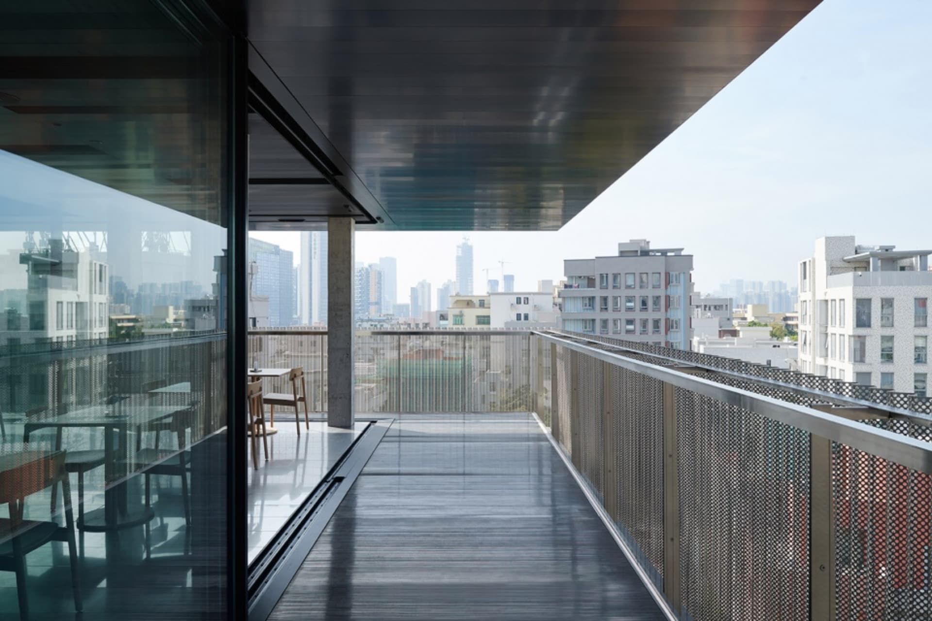 Contemporary balcony overlooking city skyline with glass, metal, and wooden materials
