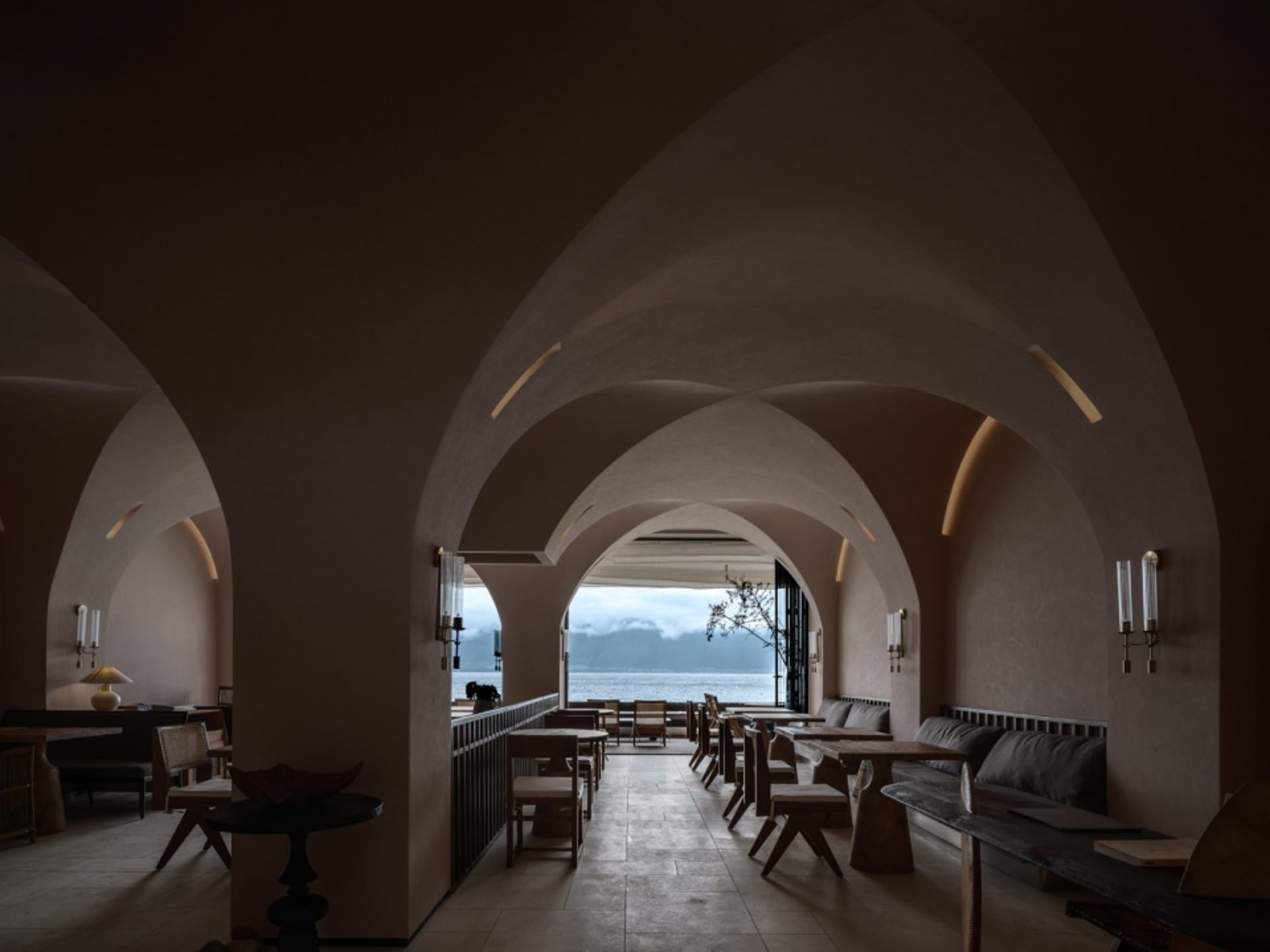 Modern coffee shop interior with wooden furniture and concrete walls.