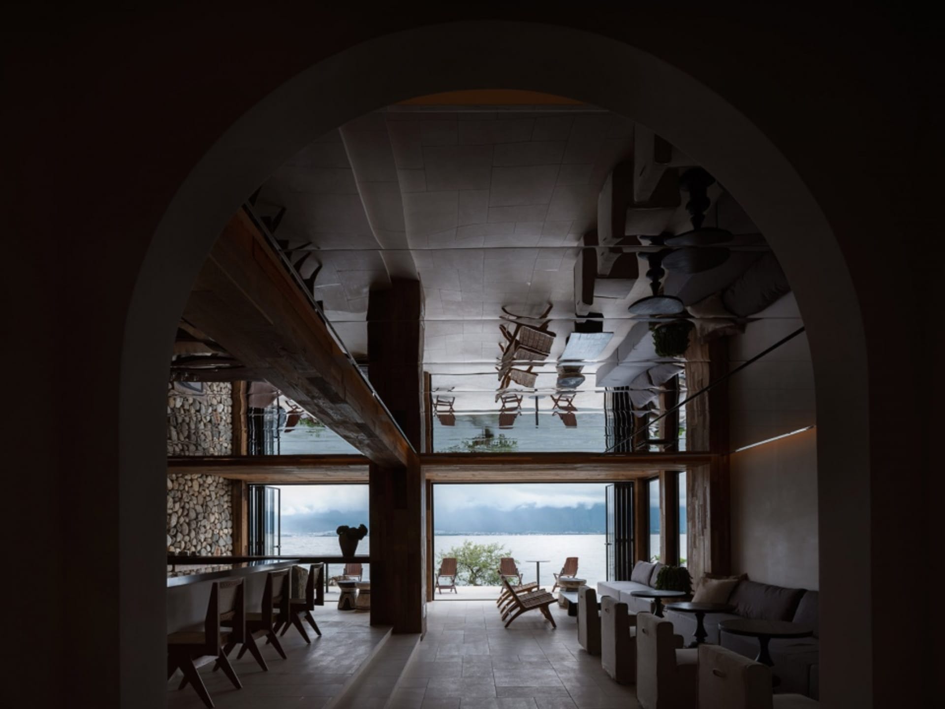 A modern bar lounge decorated with concrete walls and wooden furniture.