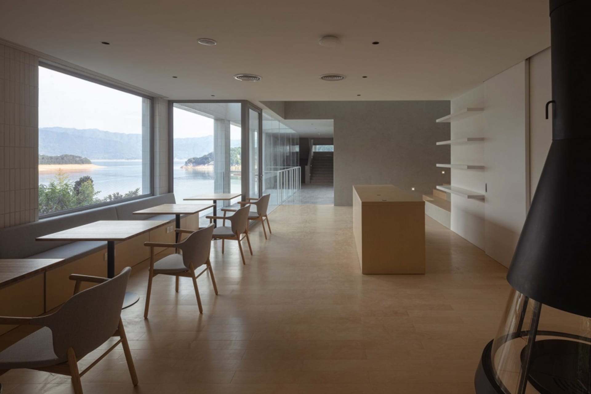 Modern living room with large windows, minimalist furniture, and natural wood accents.