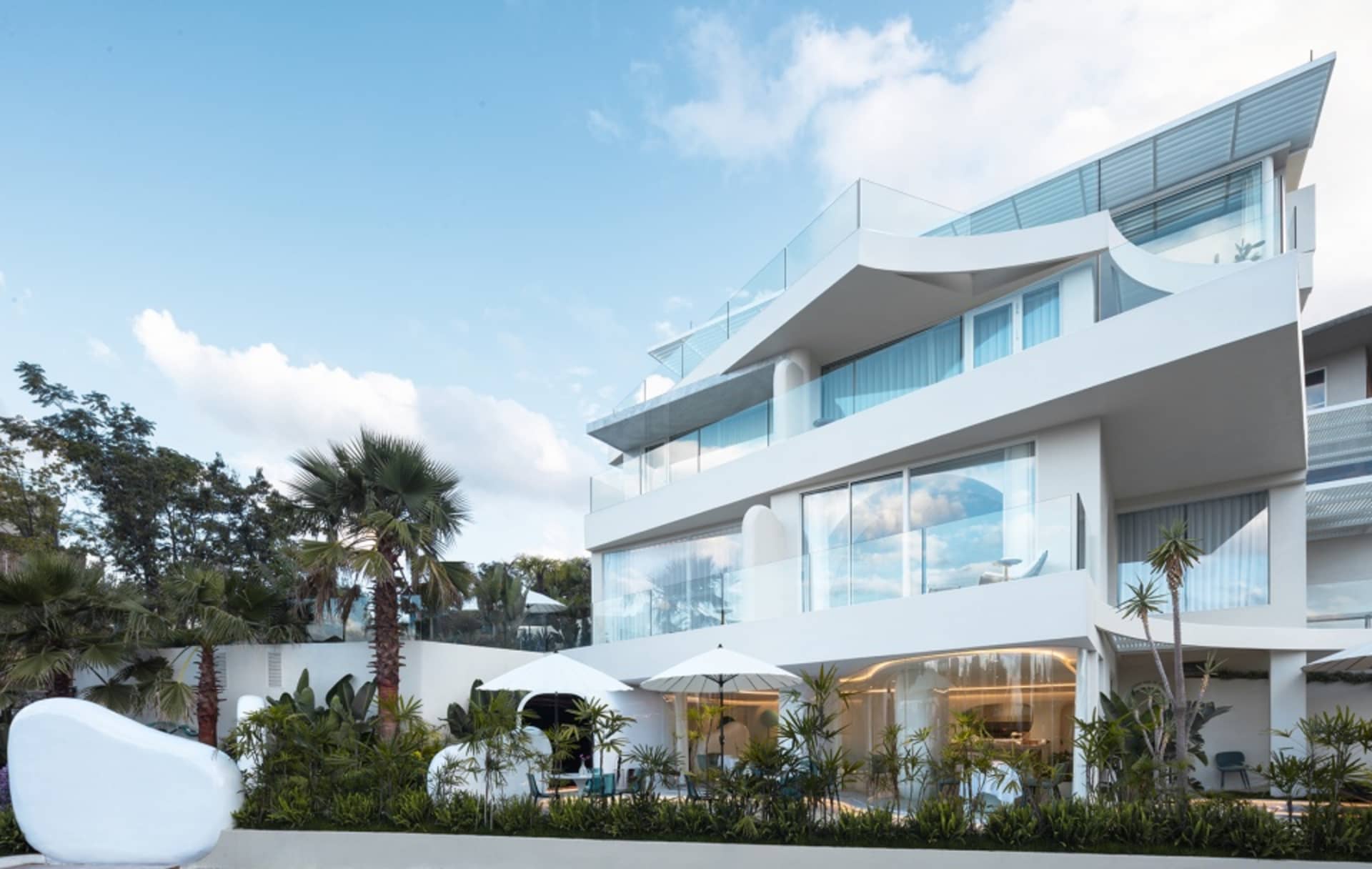 Modern residential apartment building with glass balconies and minimalist design