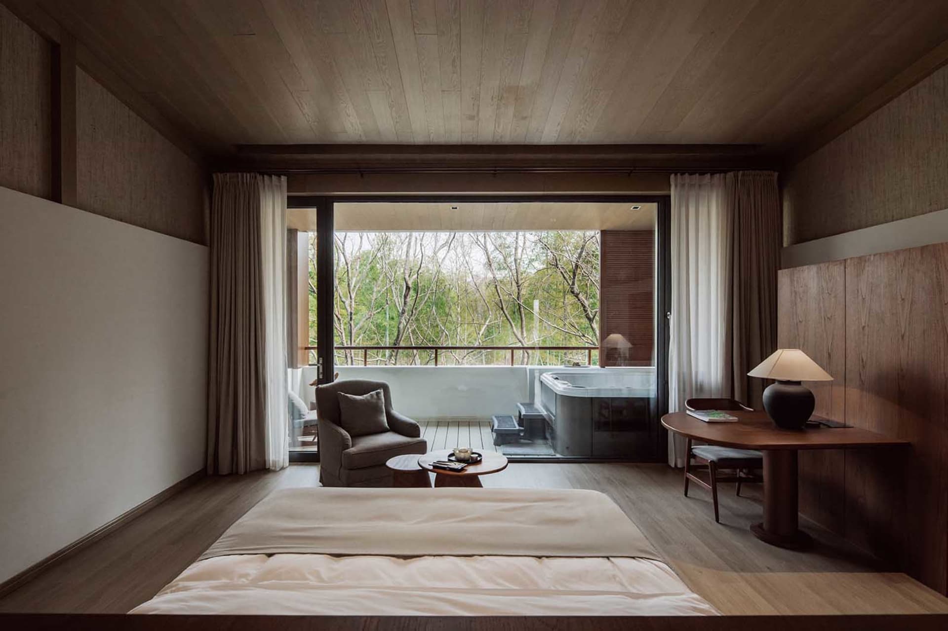 A modern residential bedroom featuring wood elements and a view of a garden.