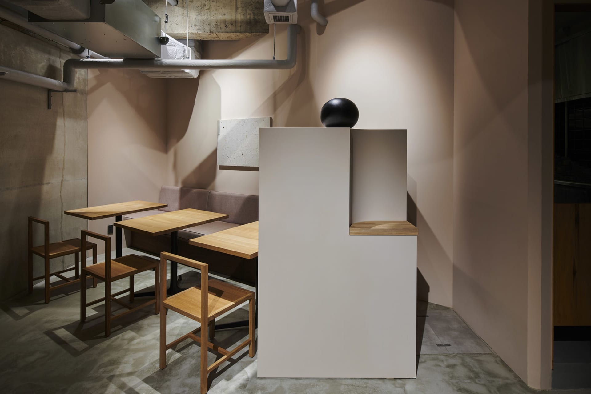 極簡風格的餐廳室內,搭配木質家具與混凝土牆面。
