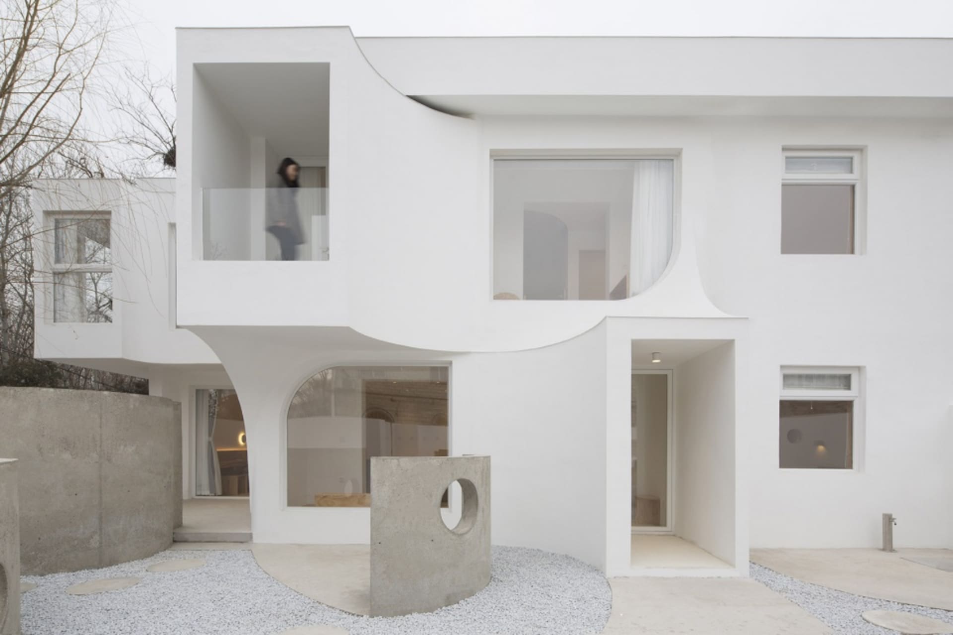 A modern white house featuring concrete and glass materials.