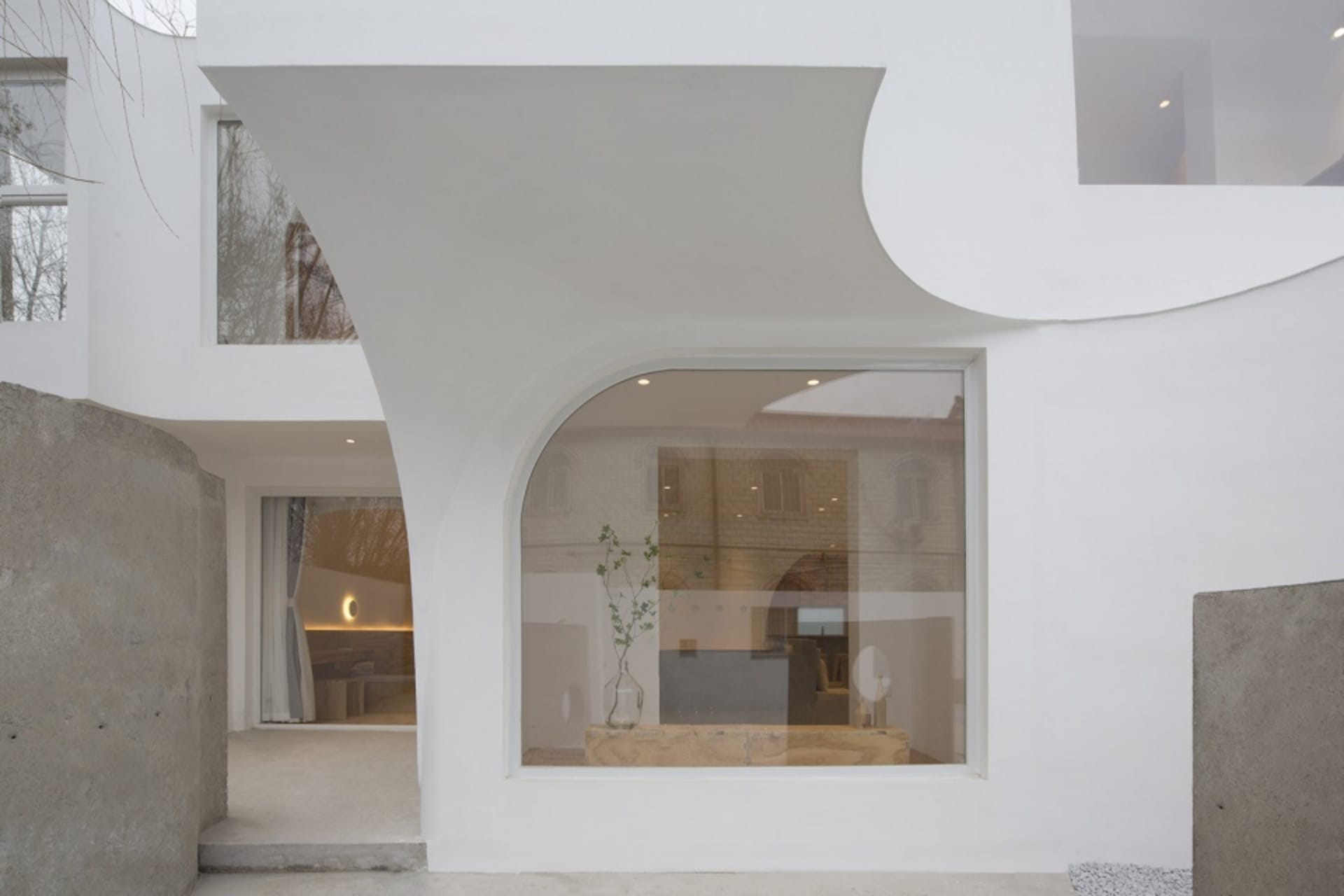 A modern interior space with a concrete structure and large windows.