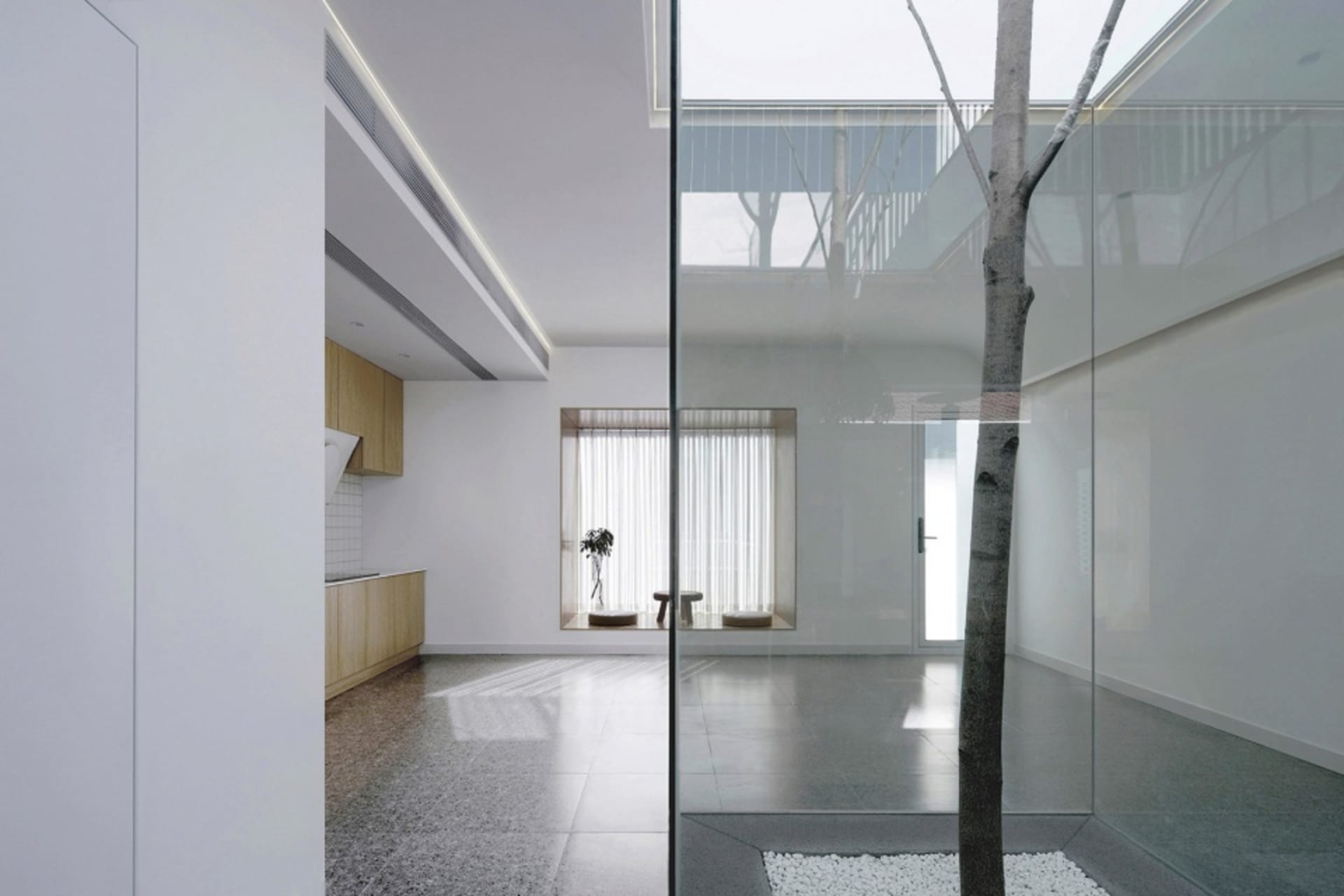 Modern minimalist living room with glass walls and concrete flooring
