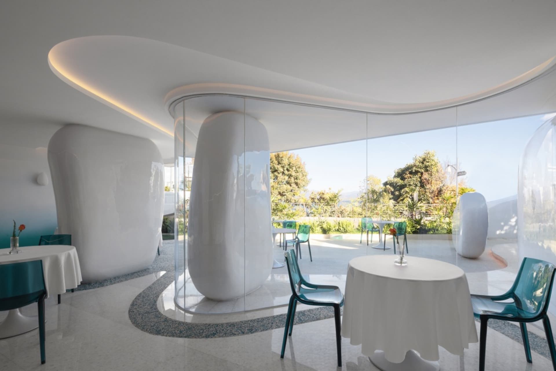 A modern restaurant interior with white tables and green chairs.