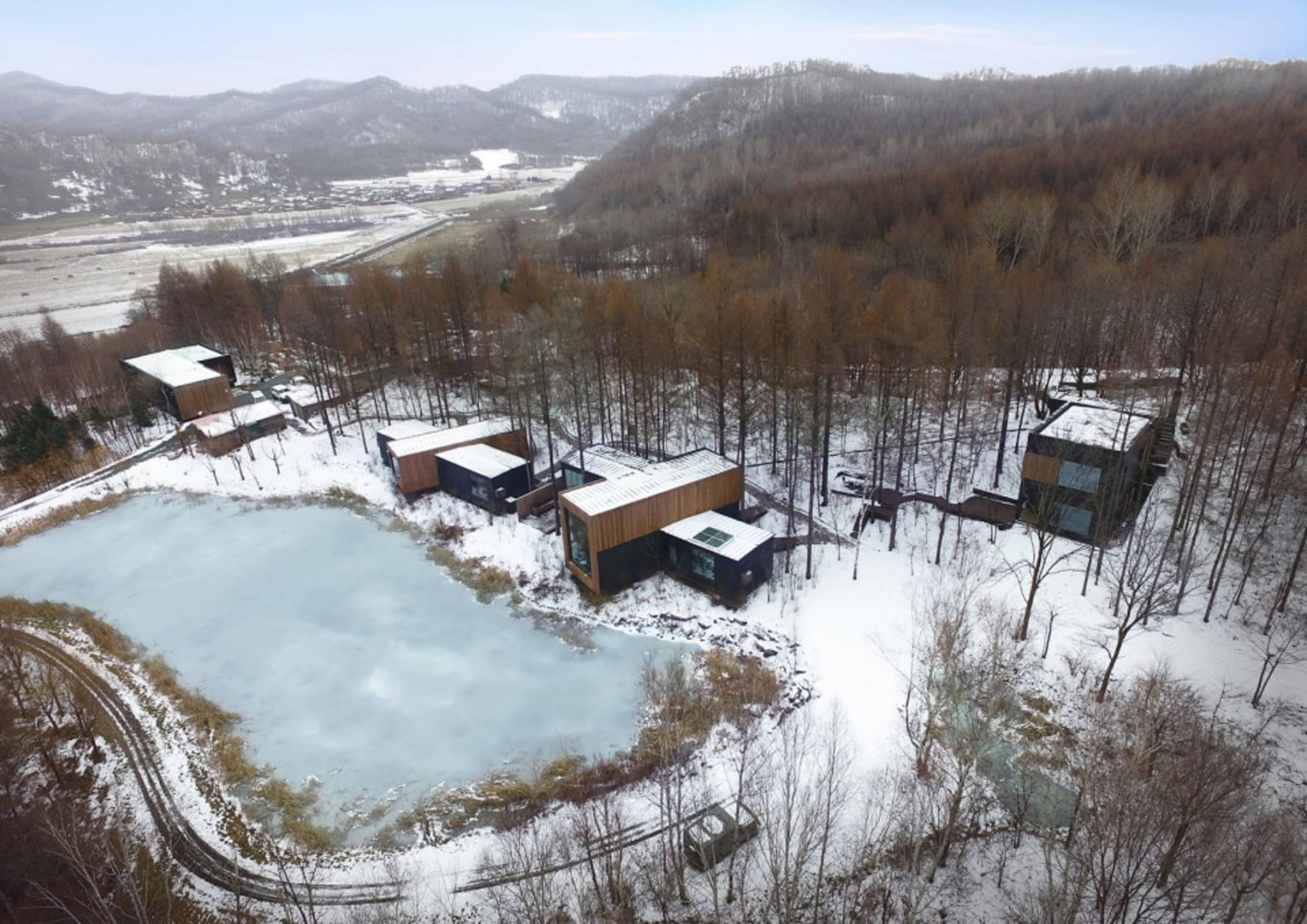 現代預製房屋被雪覆蓋的林地環繞。