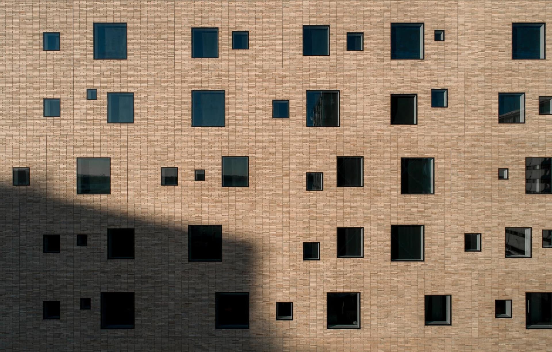 Modern brick building with various sized windows.