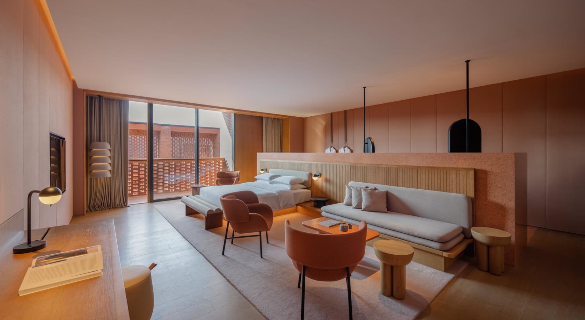 Modern hotel suite featuring concrete paneling, minimal furniture, and a serene atmosphere.