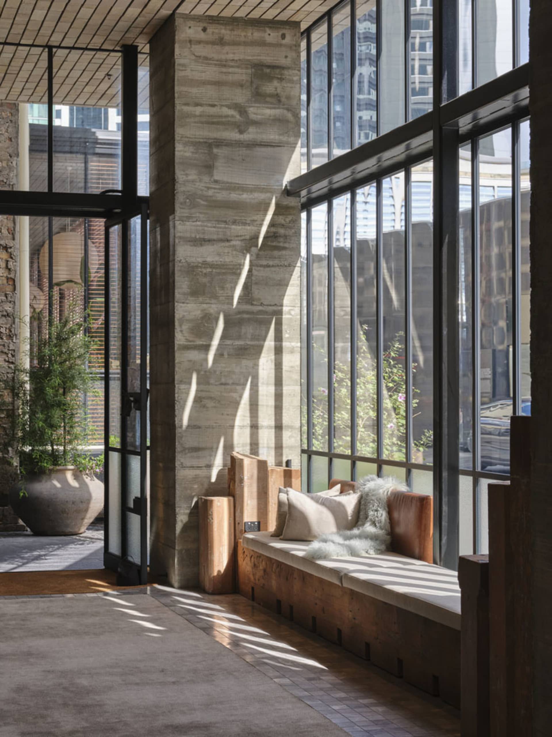 Modern lobby featuring a concrete column with glass windows, providing a minimalist and industrial aesthetic.