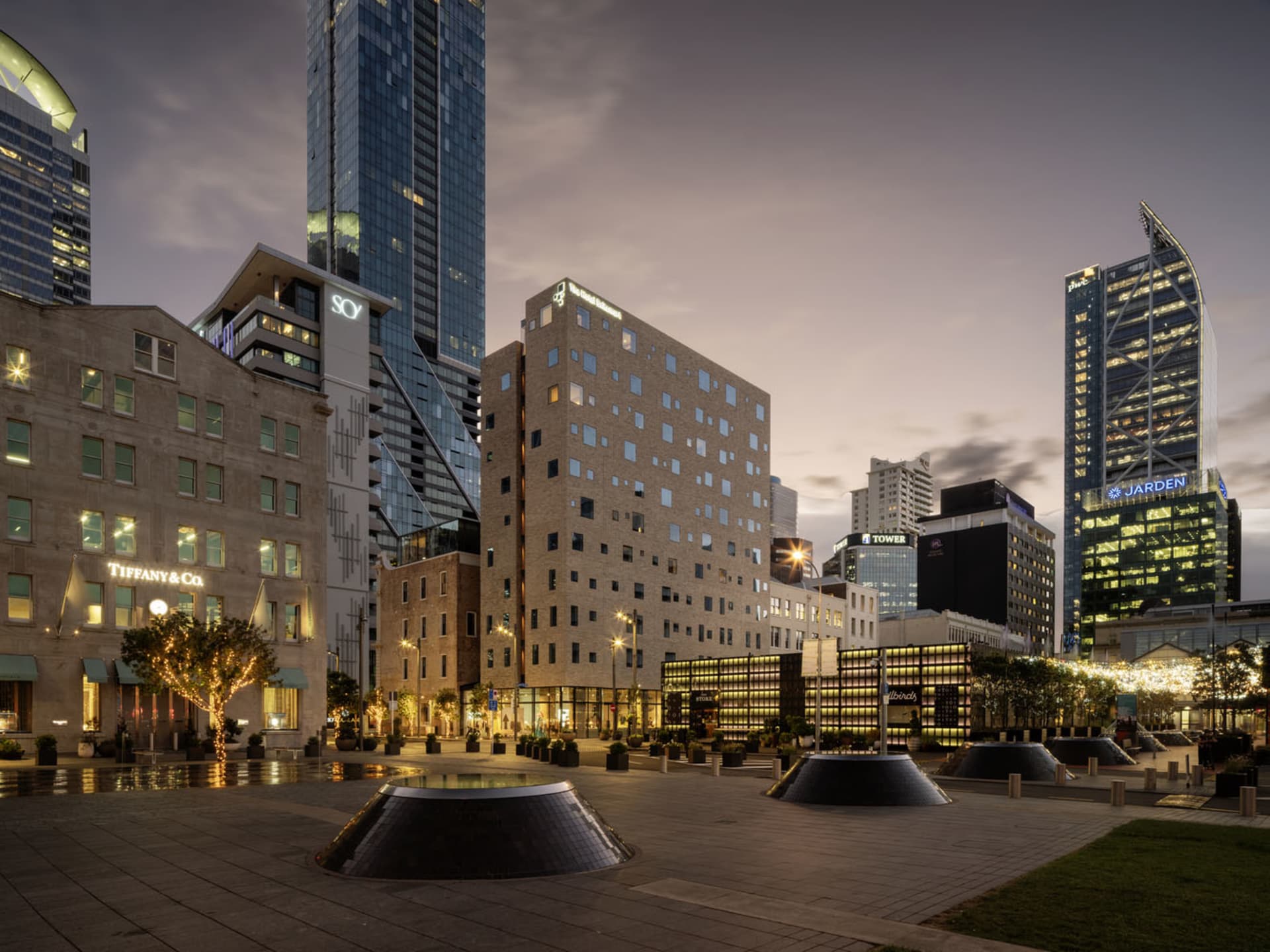 A modern cityscape featuring brick and glass buildings in an urban setting.