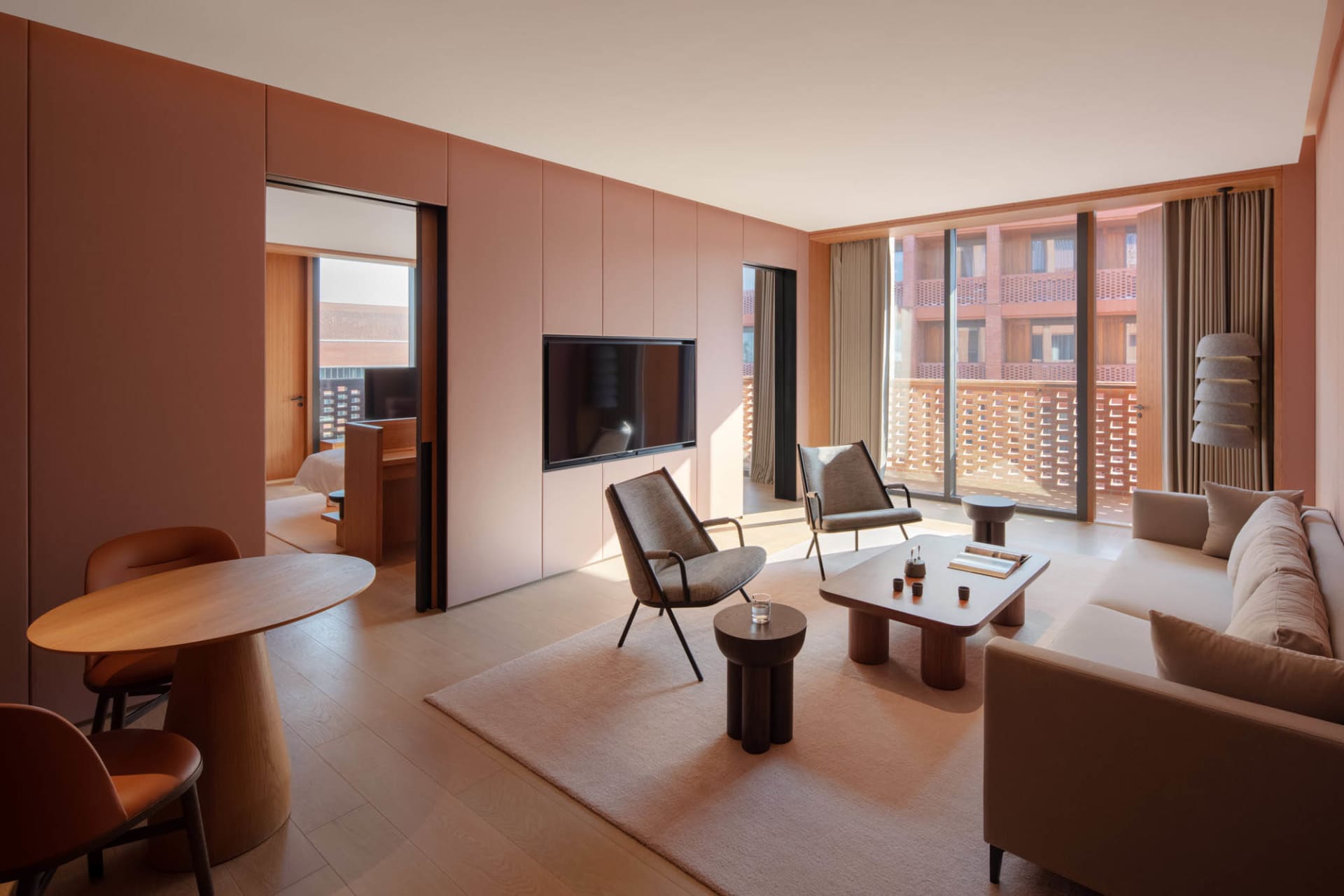 Living area with minimalist furniture and modern materials, featuring a large window with a city view.