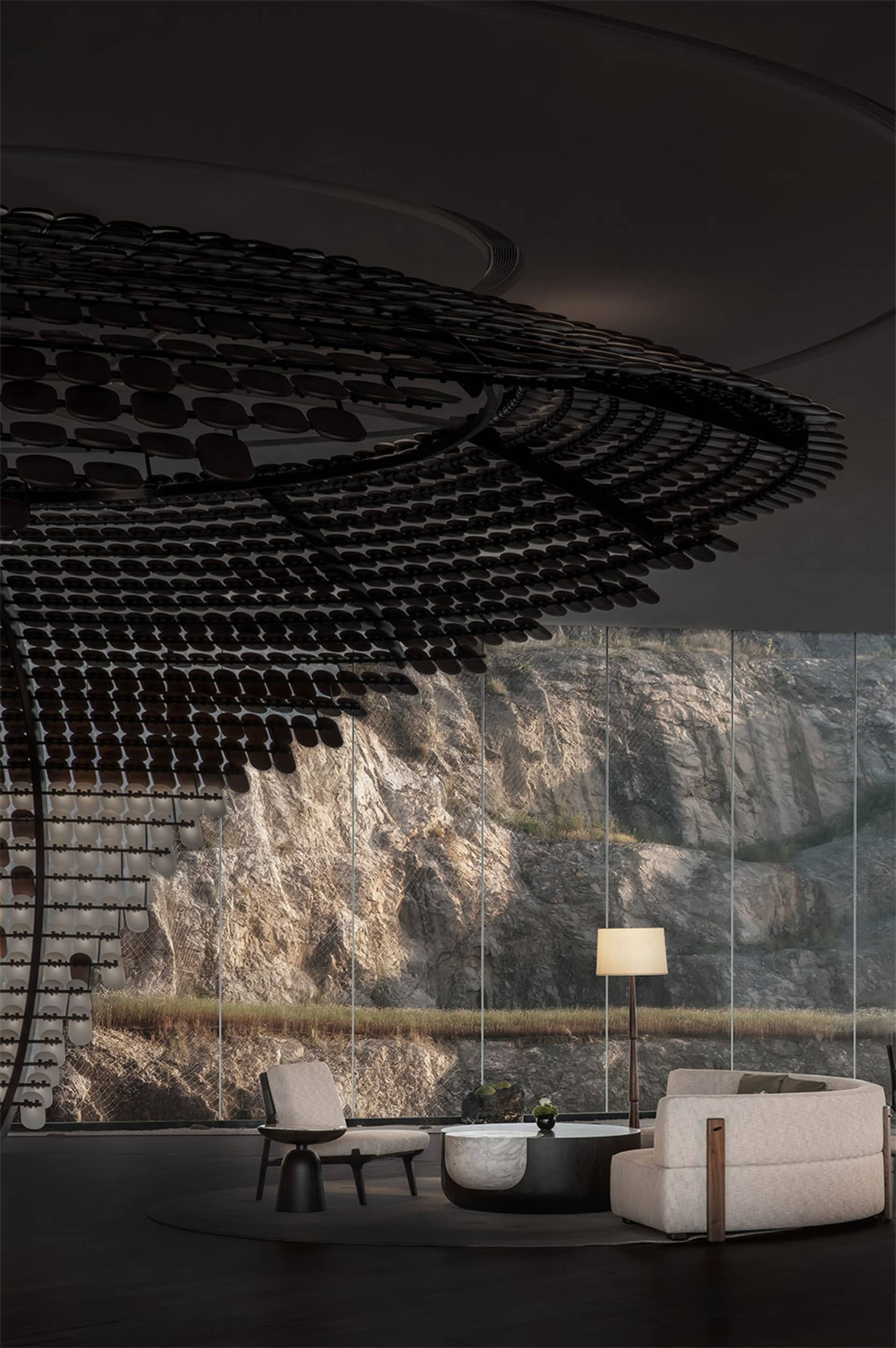 Modern living room with metal furniture and floor-to-ceiling windows overlooking a rocky landscape.