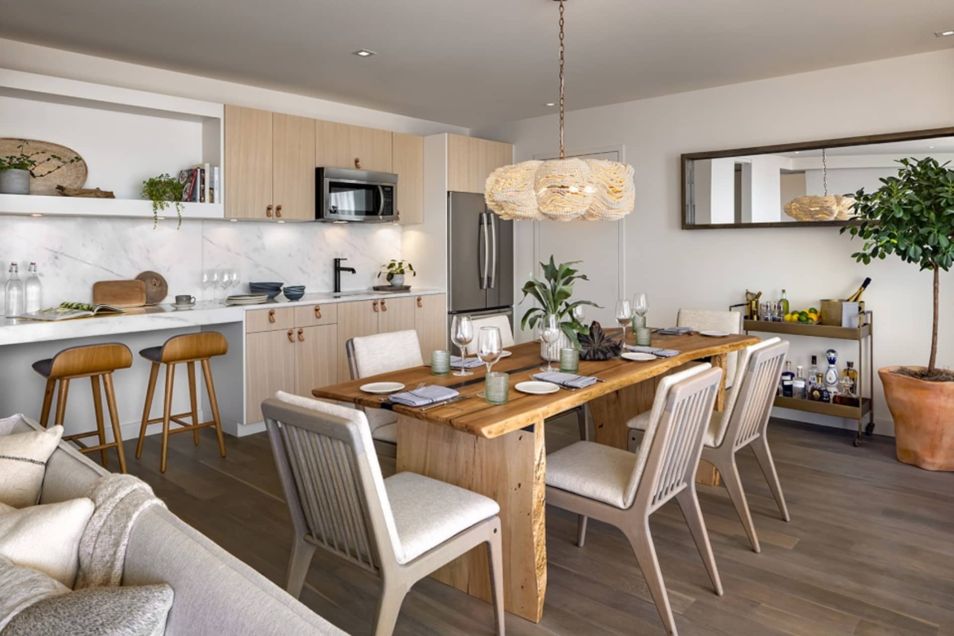 A modern residential kitchen with wooden furniture and a marble countertop.