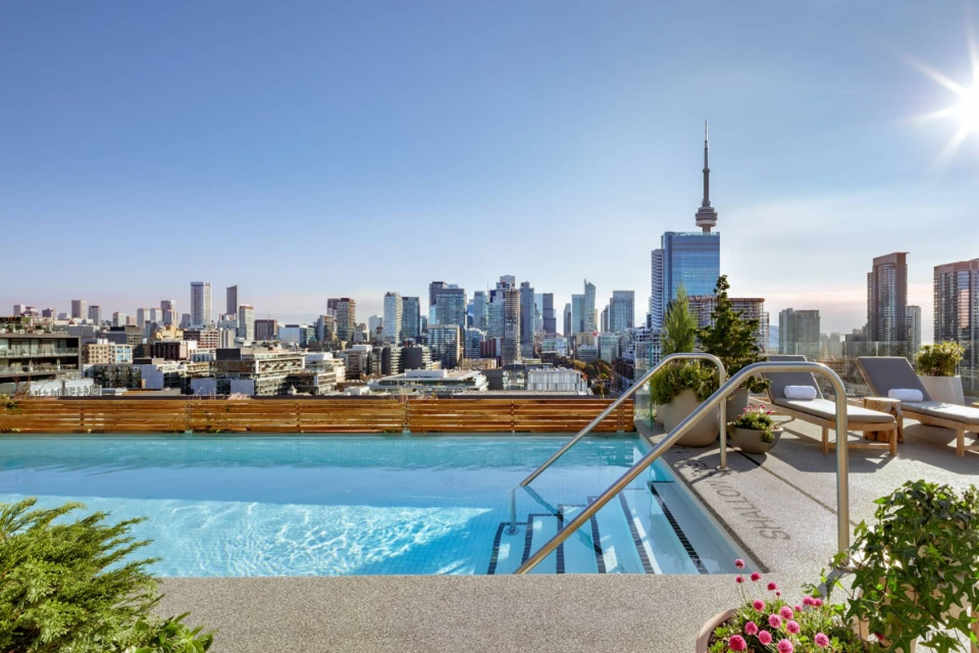A rooftop pool overlooking a cityscape with modern buildings and skyscrapers.