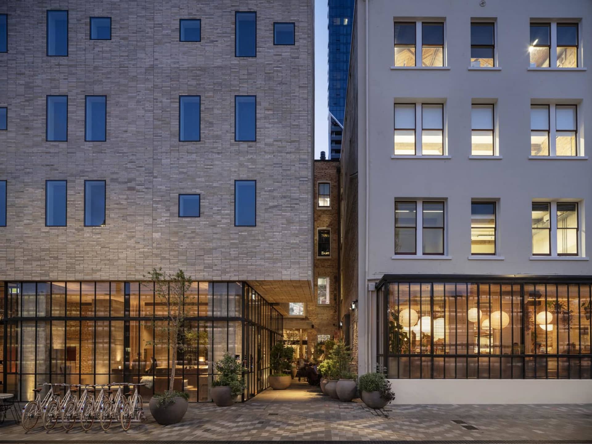 Modern interior office space featuring brick walls, concrete floors, and glass windows.