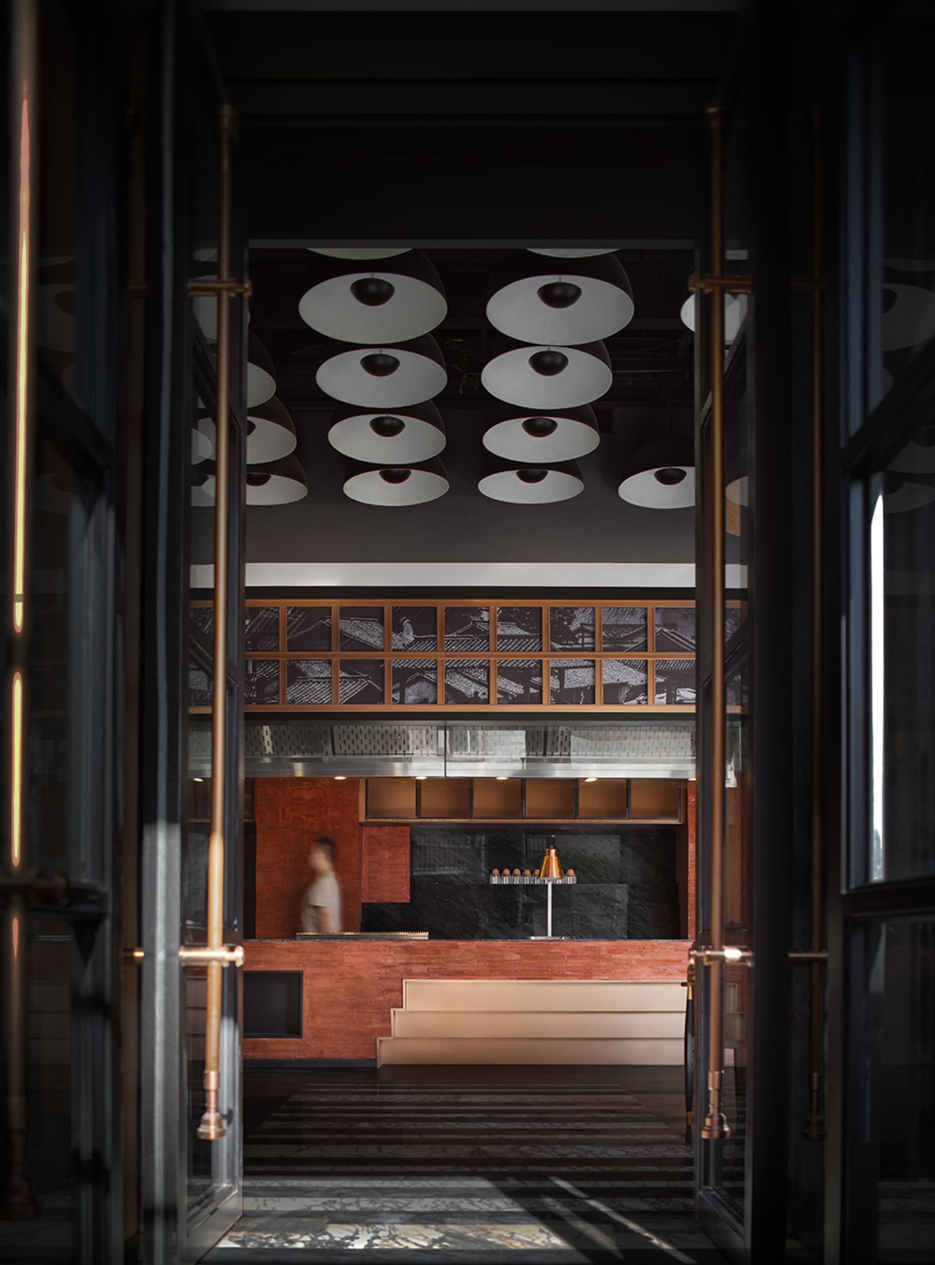A metallic lobby space with a modern and industrial feel, featuring a bar counter and abstract ceiling lights.