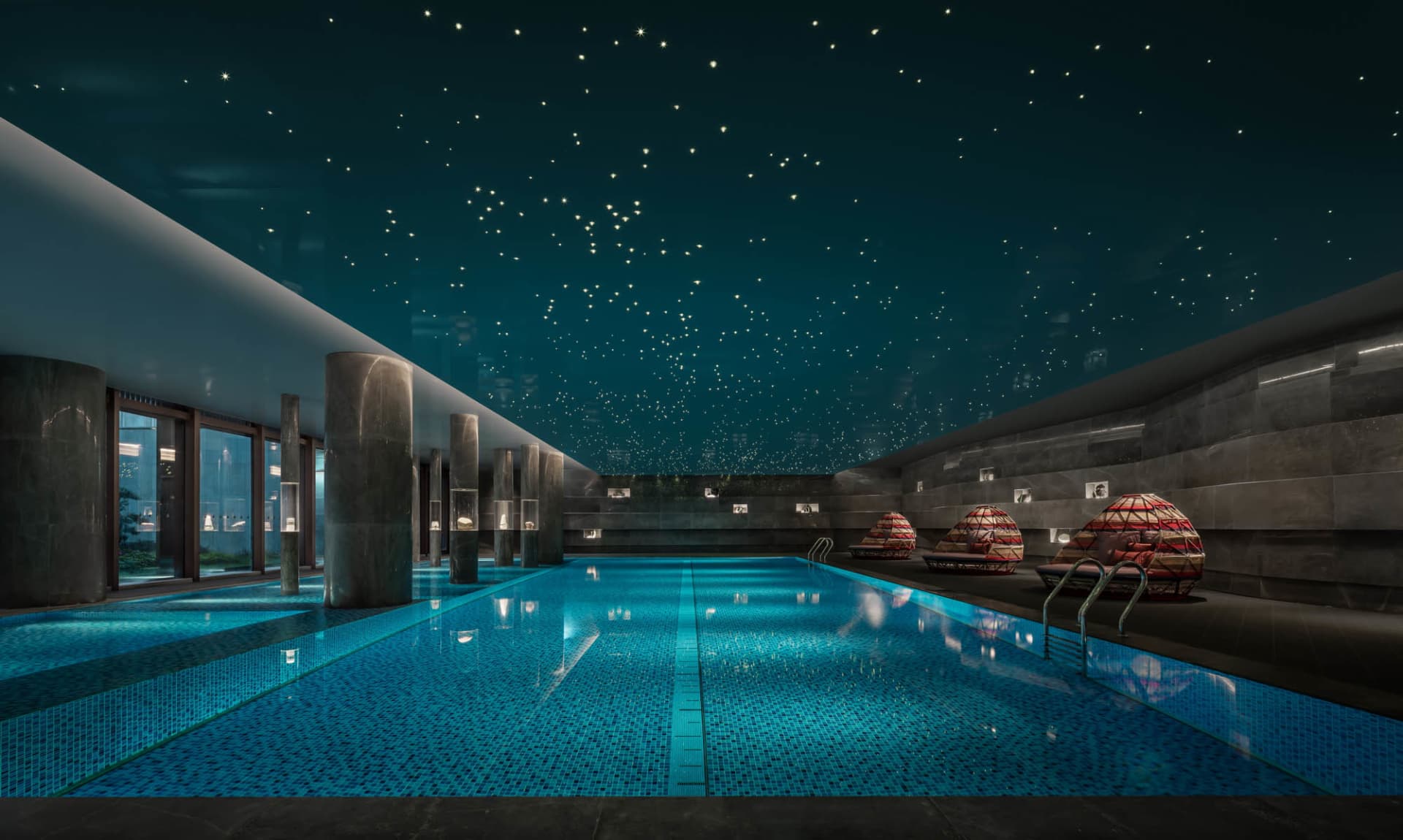 Modern indoor swimming pool with blue tiled walls and ceiling stars