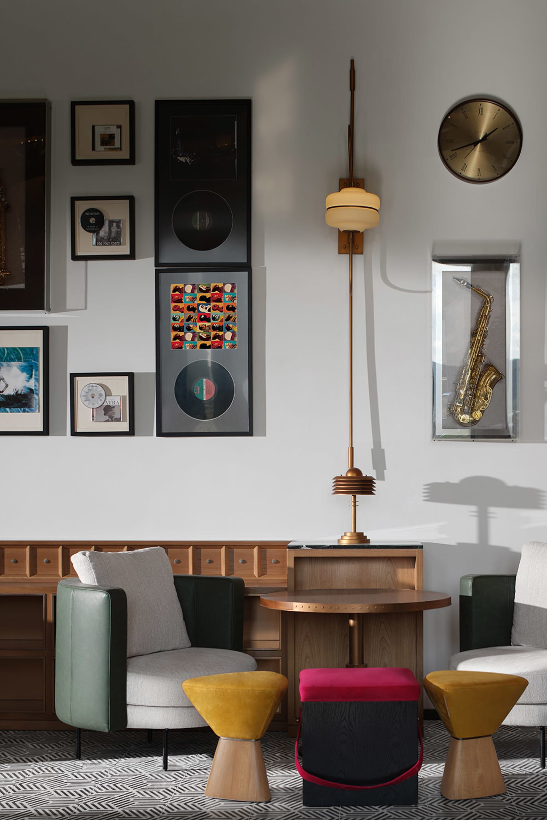 Modern living room featuring wooden furniture, colorful stools, and a wall gallery with musical memorabilia.