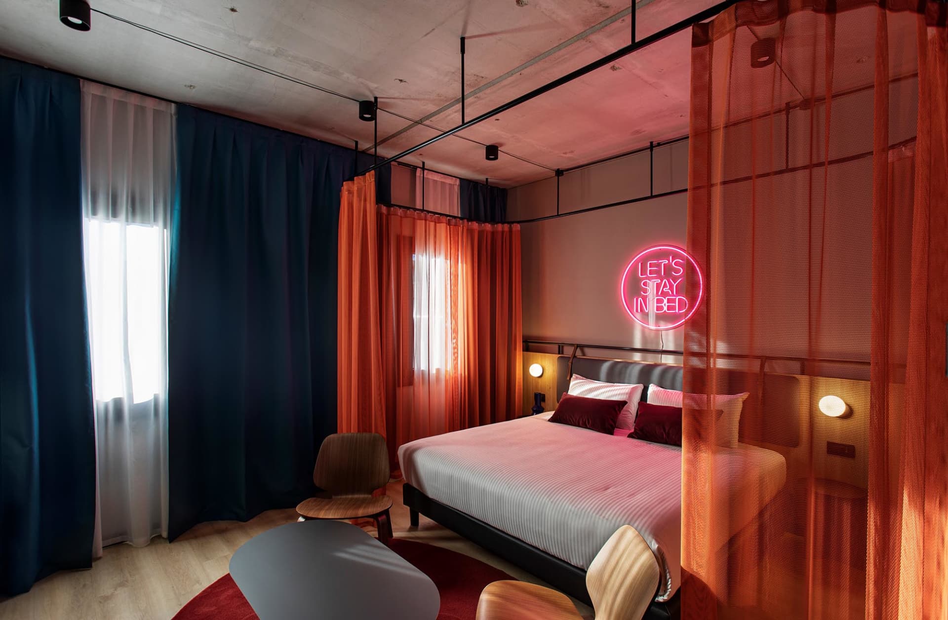 Industrial-themed bedroom with a bed, bedside tables, and textured textiles