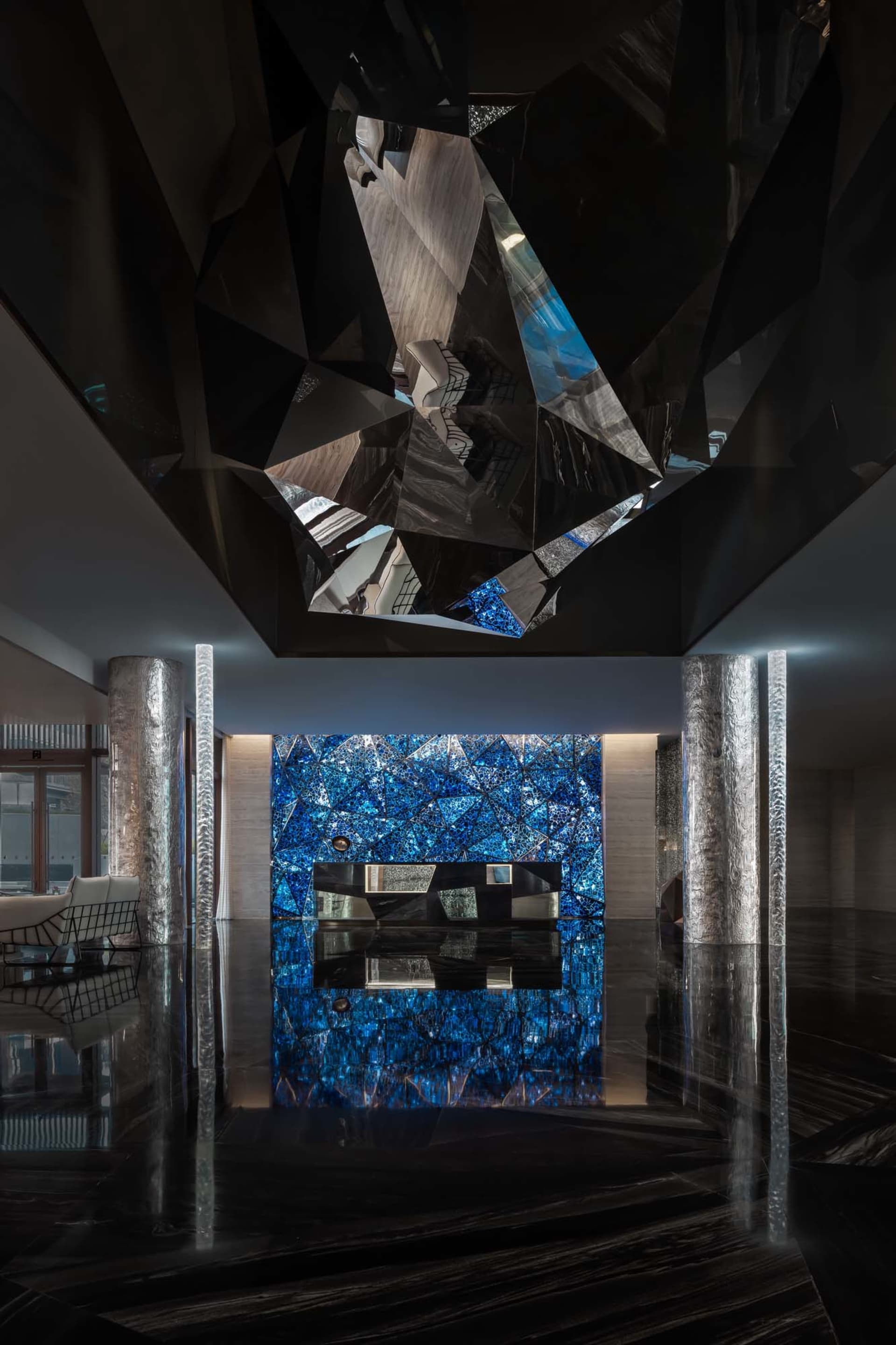 A modern lobby with marble columns and a glass ceiling.