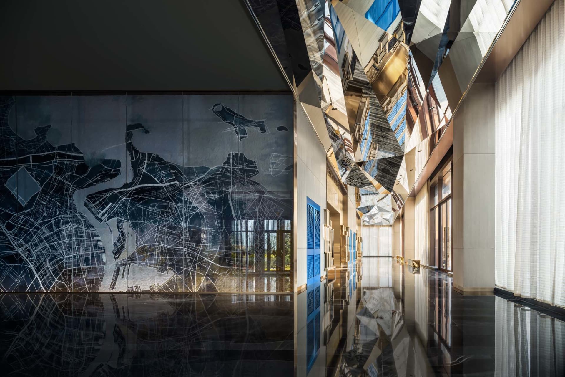 A modern interior design featuring a glass ceiling that creates reflections on the corridor floor.