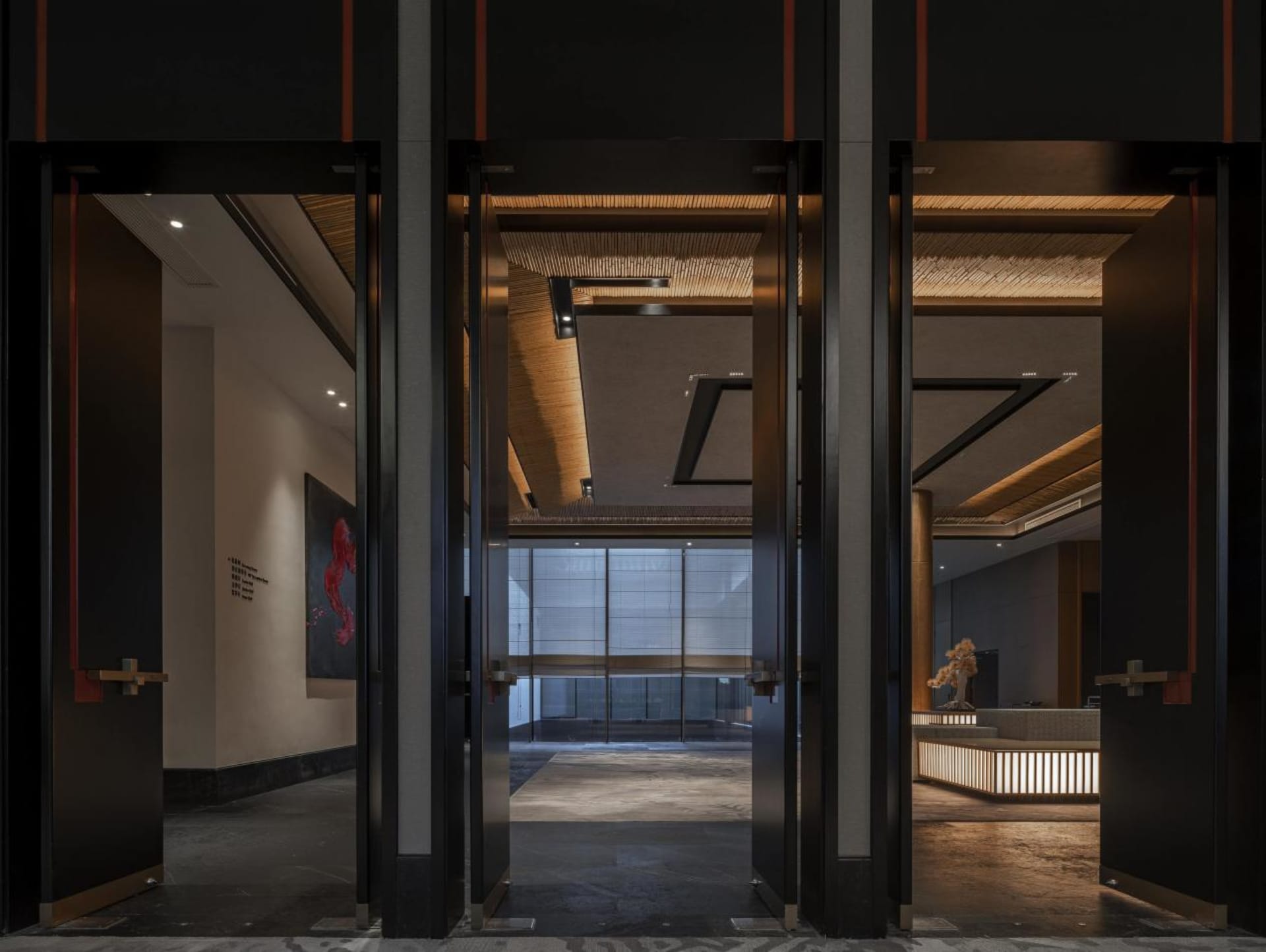 A modern lobby featuring metal walls and wooden ceiling beams.