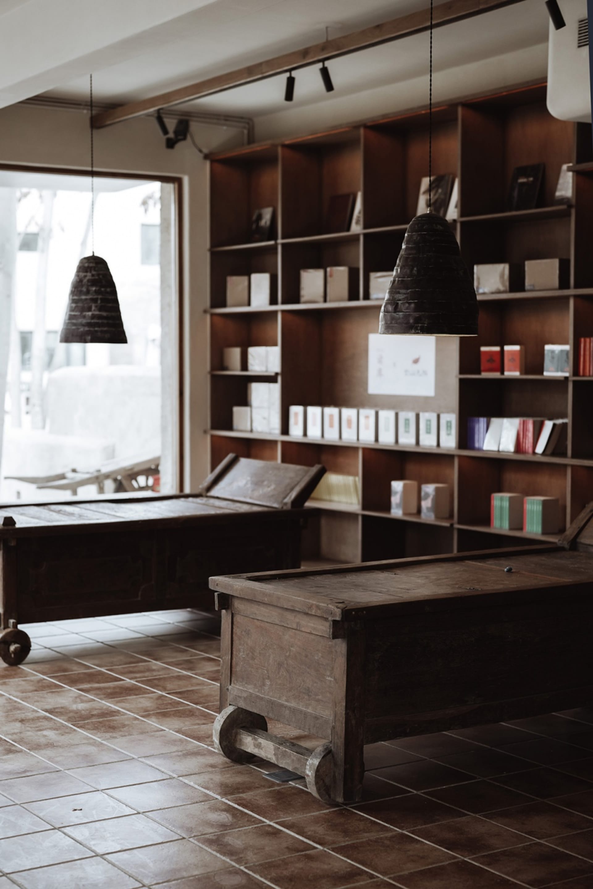 An industrial retail space featuring wooden furniture and shelves filled with books.