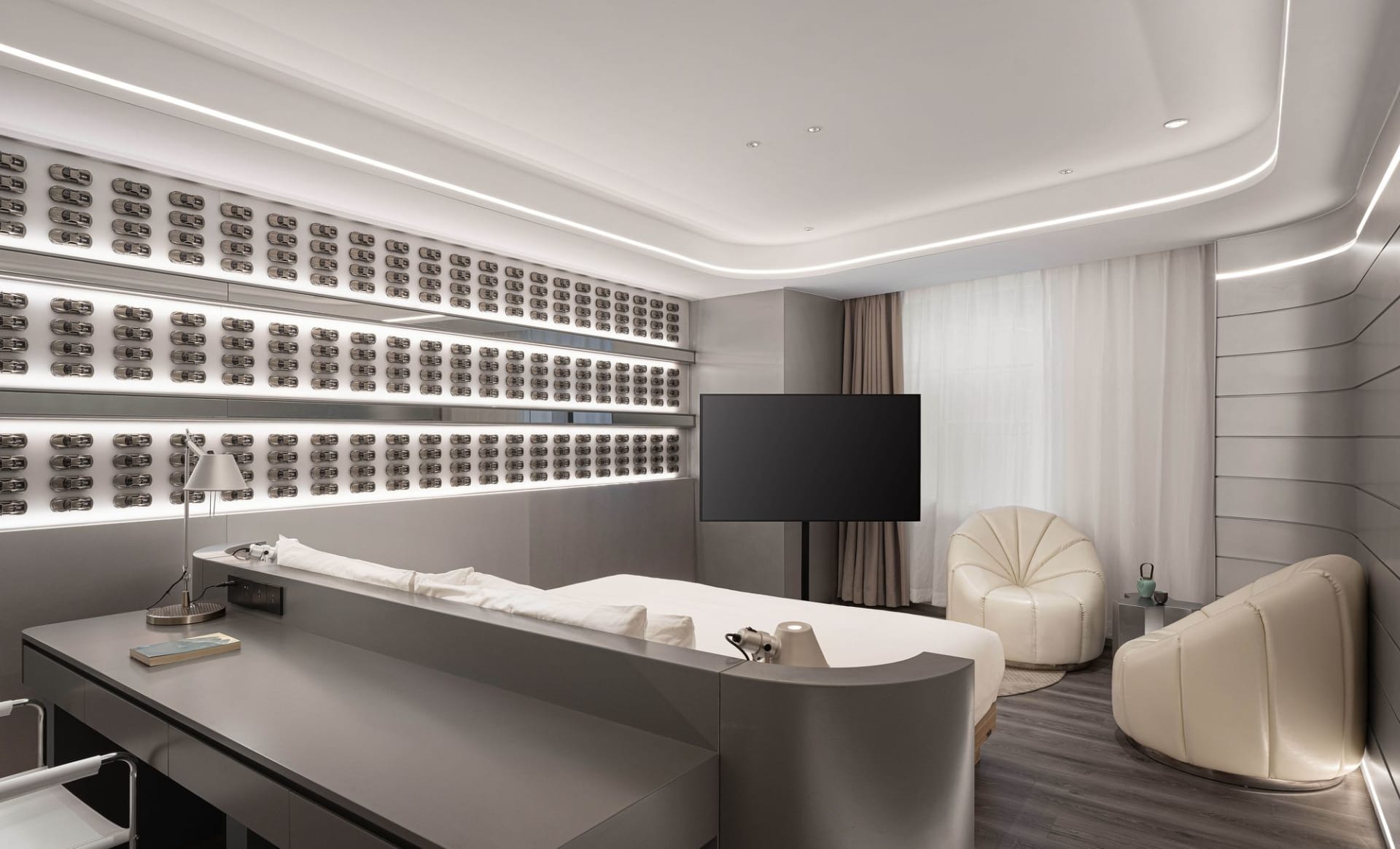 A sleek, modern hotel room featuring metallic finishes and a minimalist design.