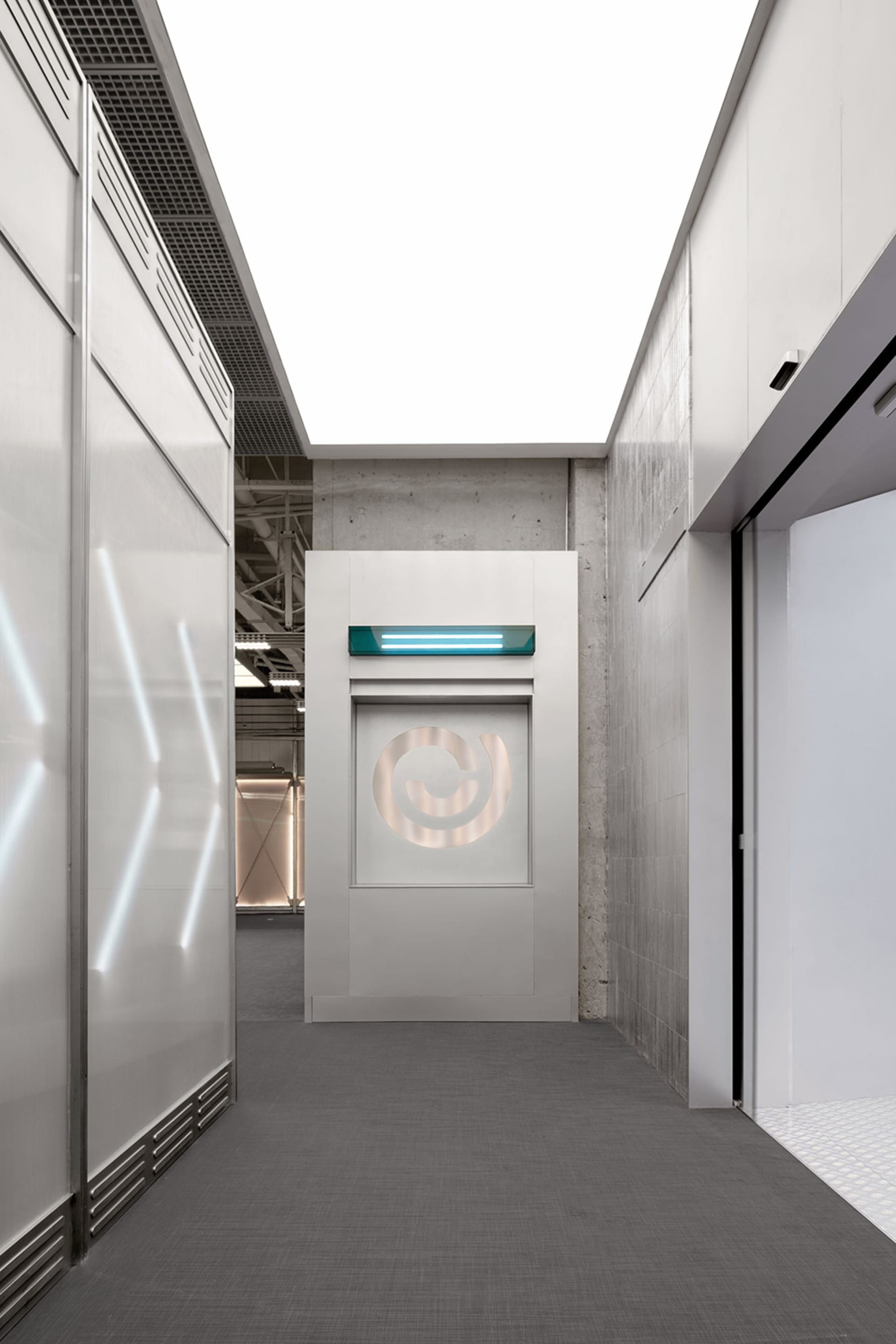 A sleek, modern industrial office entryway with concrete walls, glass panels, and minimalistic design.