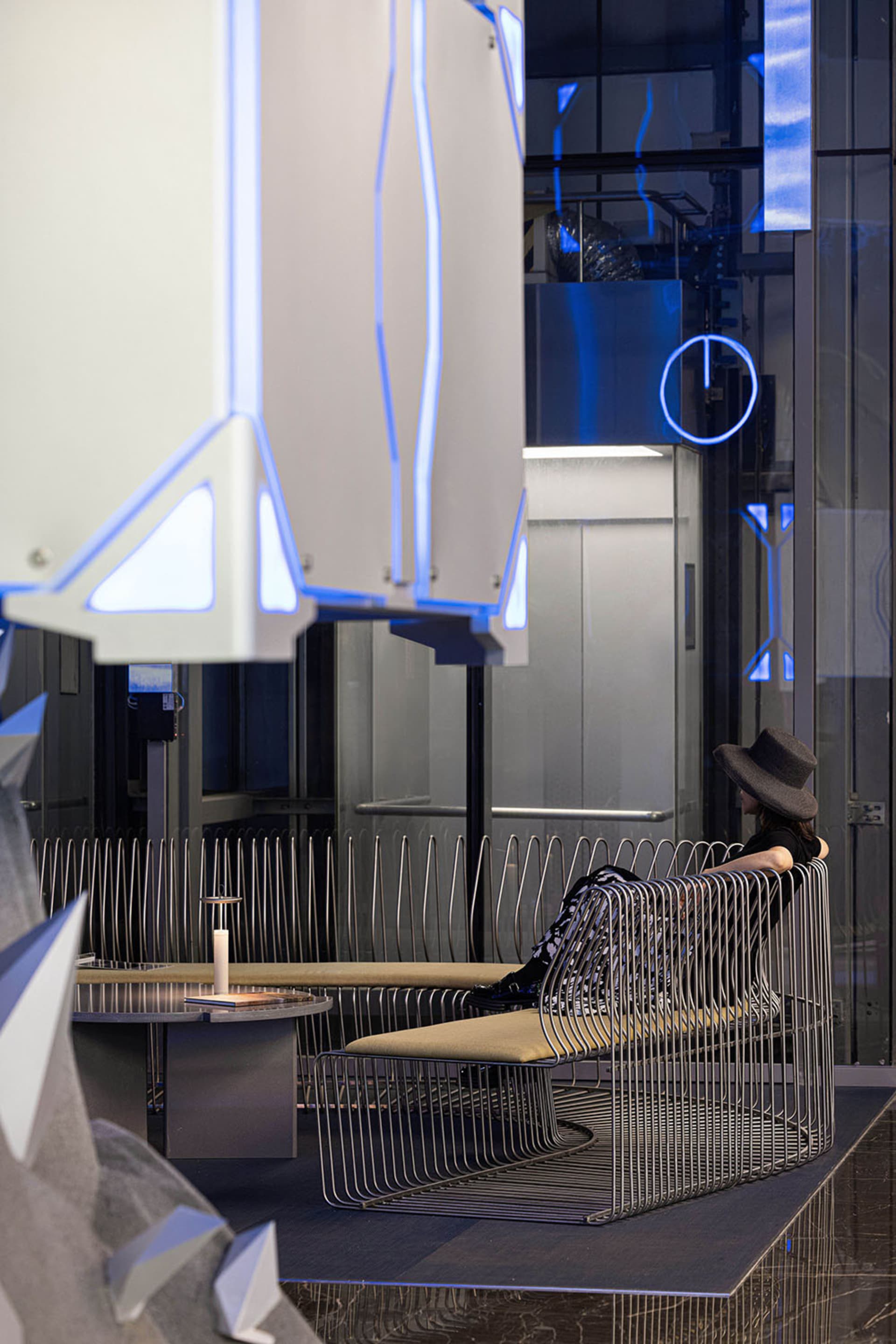 A modern, minimalist corporate lobby with metallic wire mesh seating and sleek design elements.